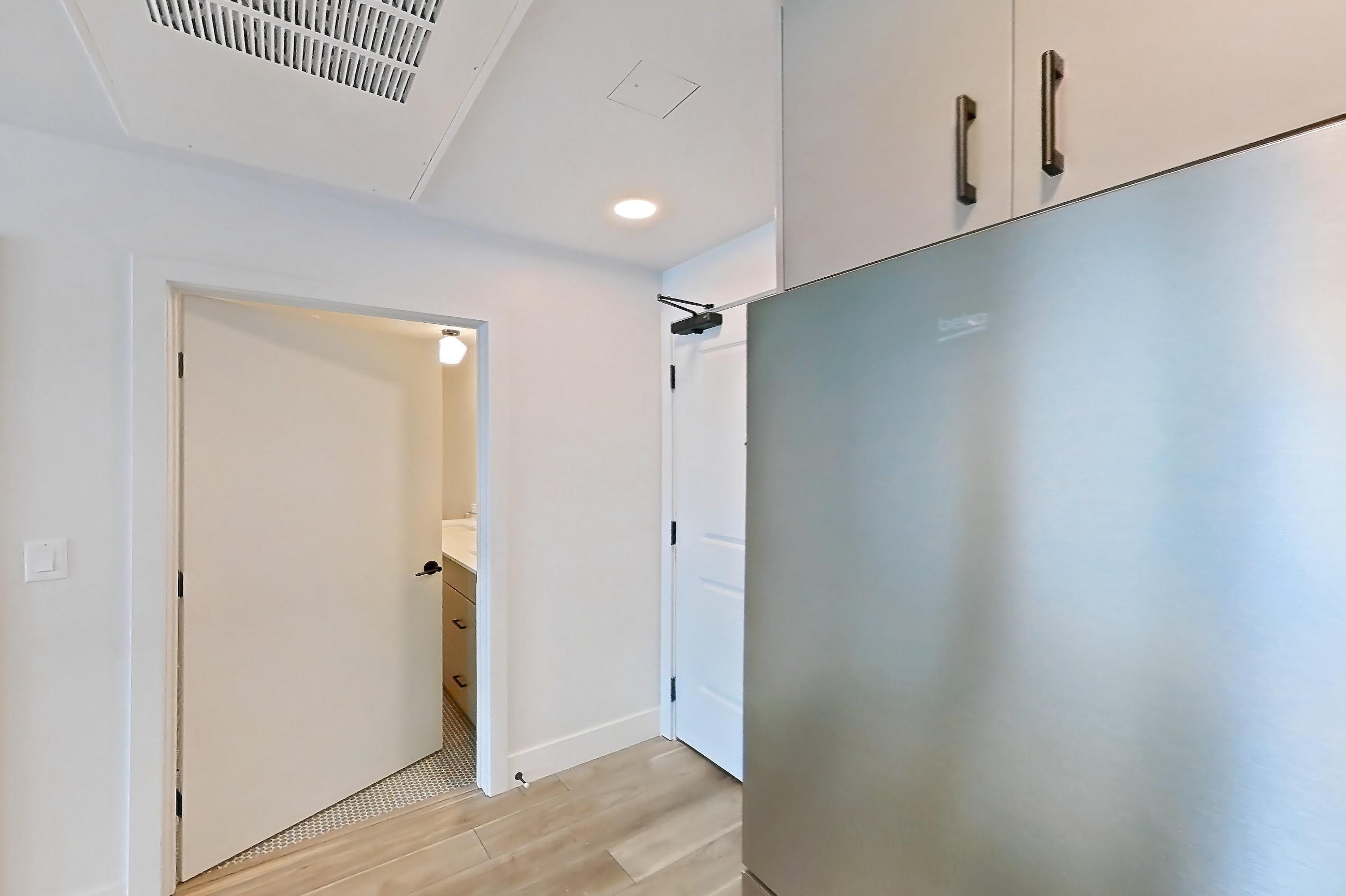 Kitchen with dishwasher, gas range, light countertops, light wood-finish flooring, microwave, oven/range, refrigerator, and stainless steel appliances, Apartment 703 at The Myles