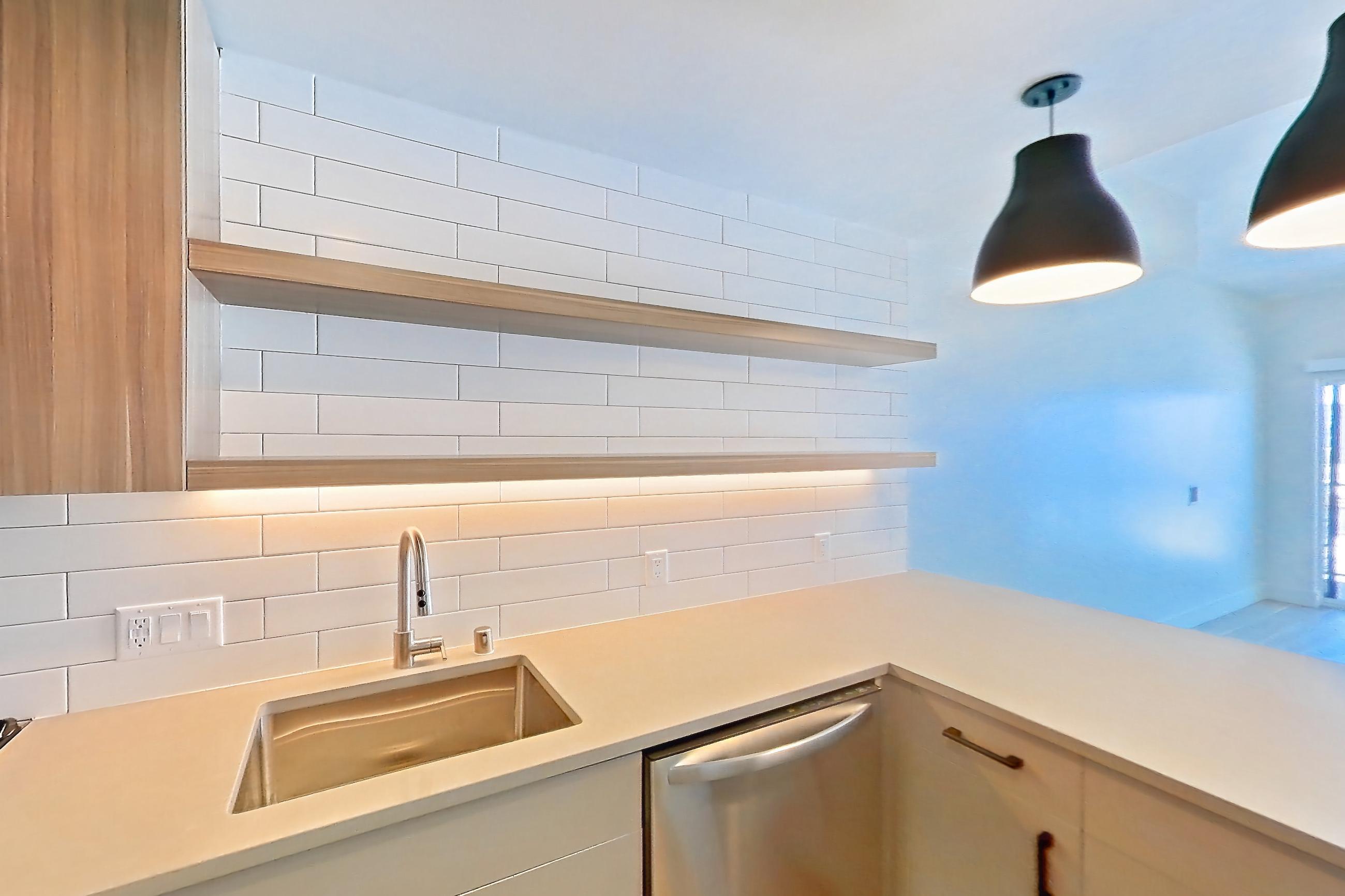 Kitchen with dishwasher, gas range, light countertops, light wood-finish flooring, microwave, oven/range, refrigerator, and stainless steel appliances, Apartment 709 at The Myles