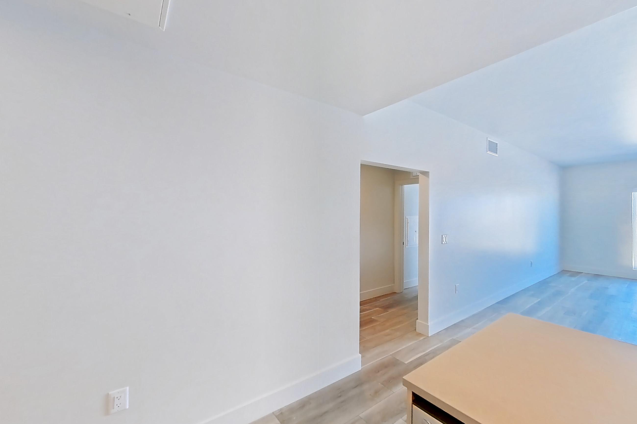 Kitchen with dishwasher, gas range, light countertops, light wood-finish flooring, oven/range, refrigerator, and stainless steel appliances, Apartment 750 at The Myles