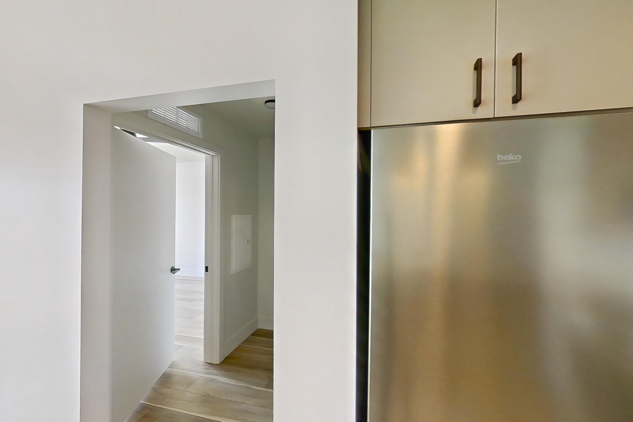 Kitchen with dishwasher, gas range, light countertops, light wood-finish flooring, microwave, oven/range, refrigerator, and stainless steel appliances, Apartment 754 at The Myles