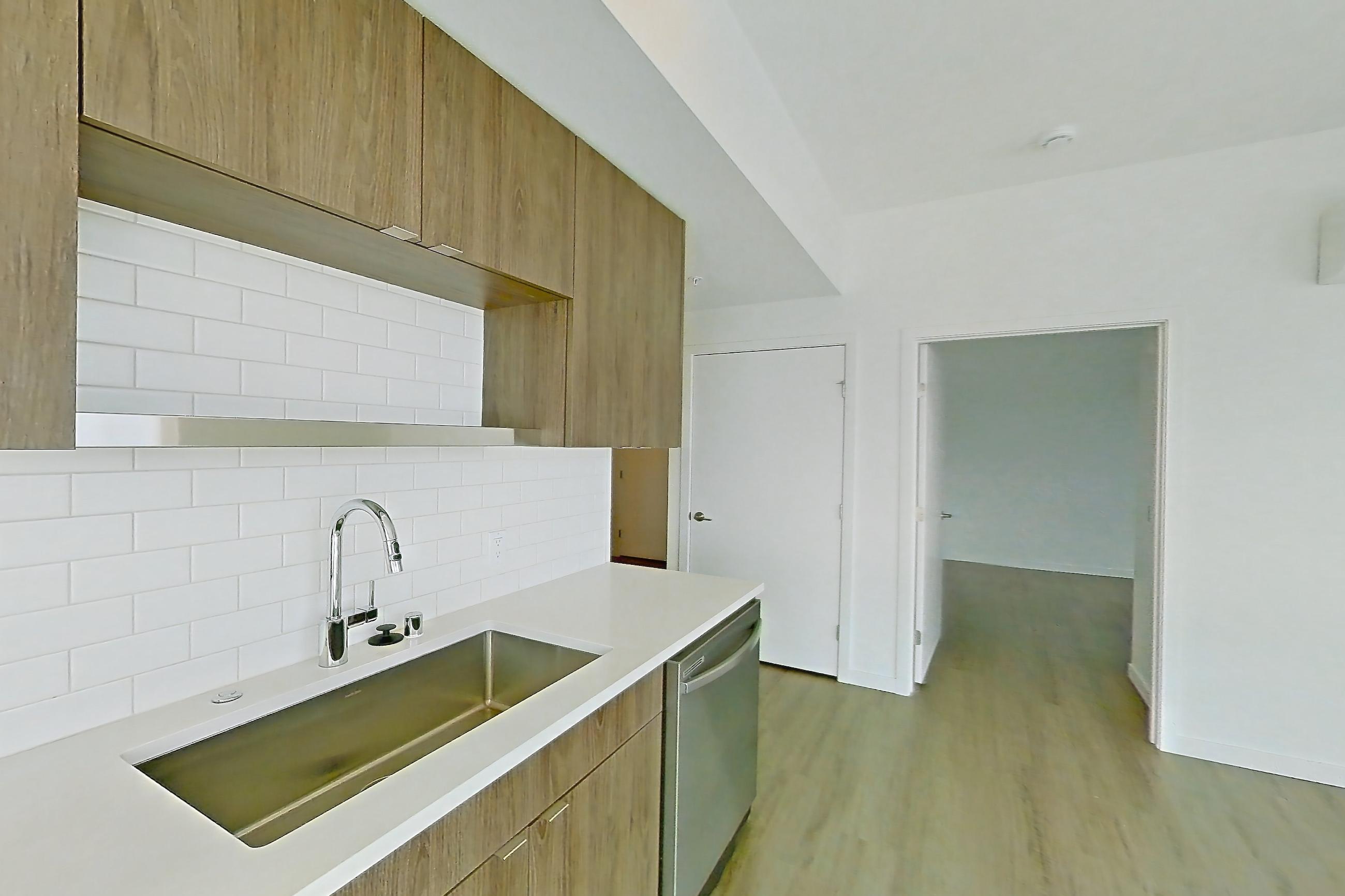 Kitchen with dishwasher, electric range, light countertops, light wood-finish flooring, microwave, mini-split AC, oven/range, refrigerator, and stainless steel appliances, Apartment 835 at The Cline