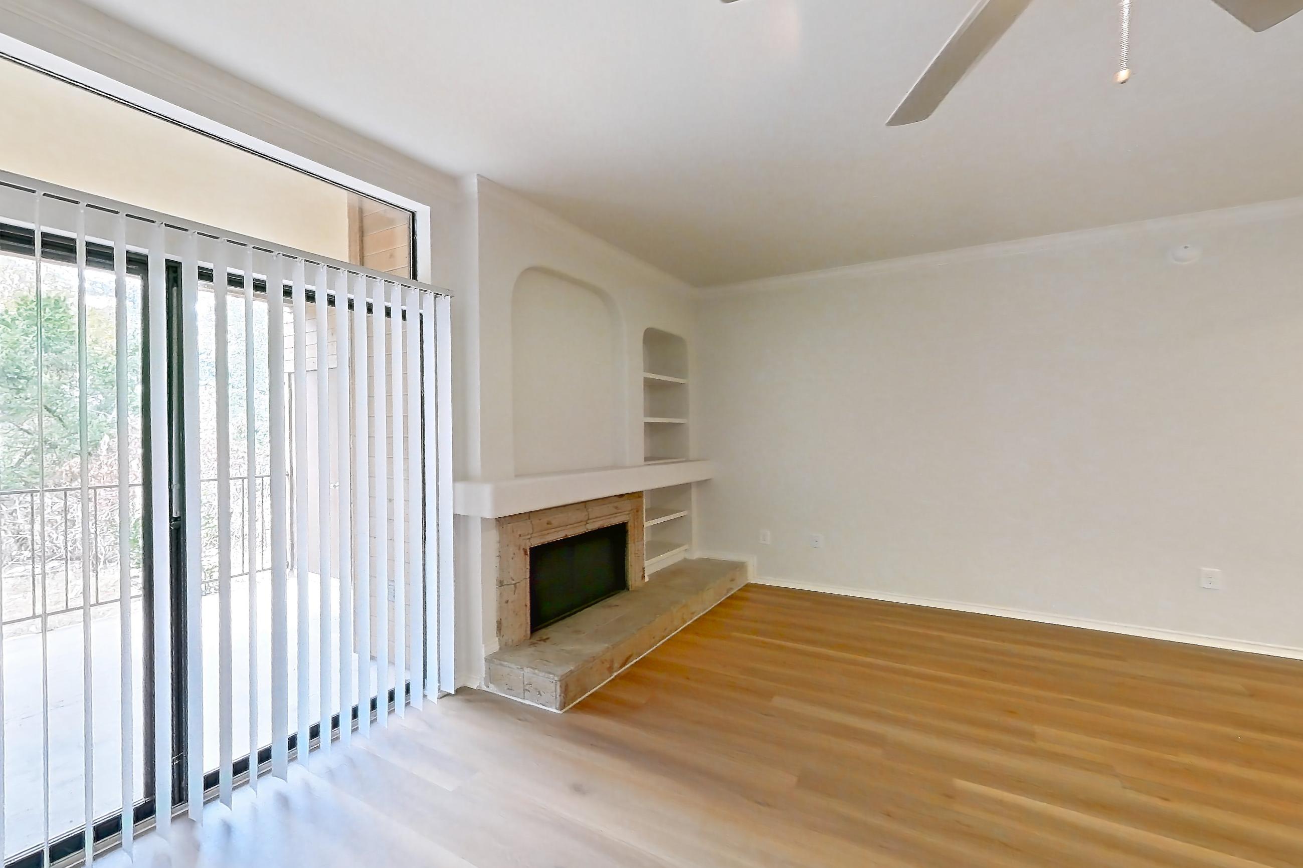 Living space with fireplace, light wood-finish flooring, and stone fireplace, Apartment 2001 at Marquis at Caprock Canyon