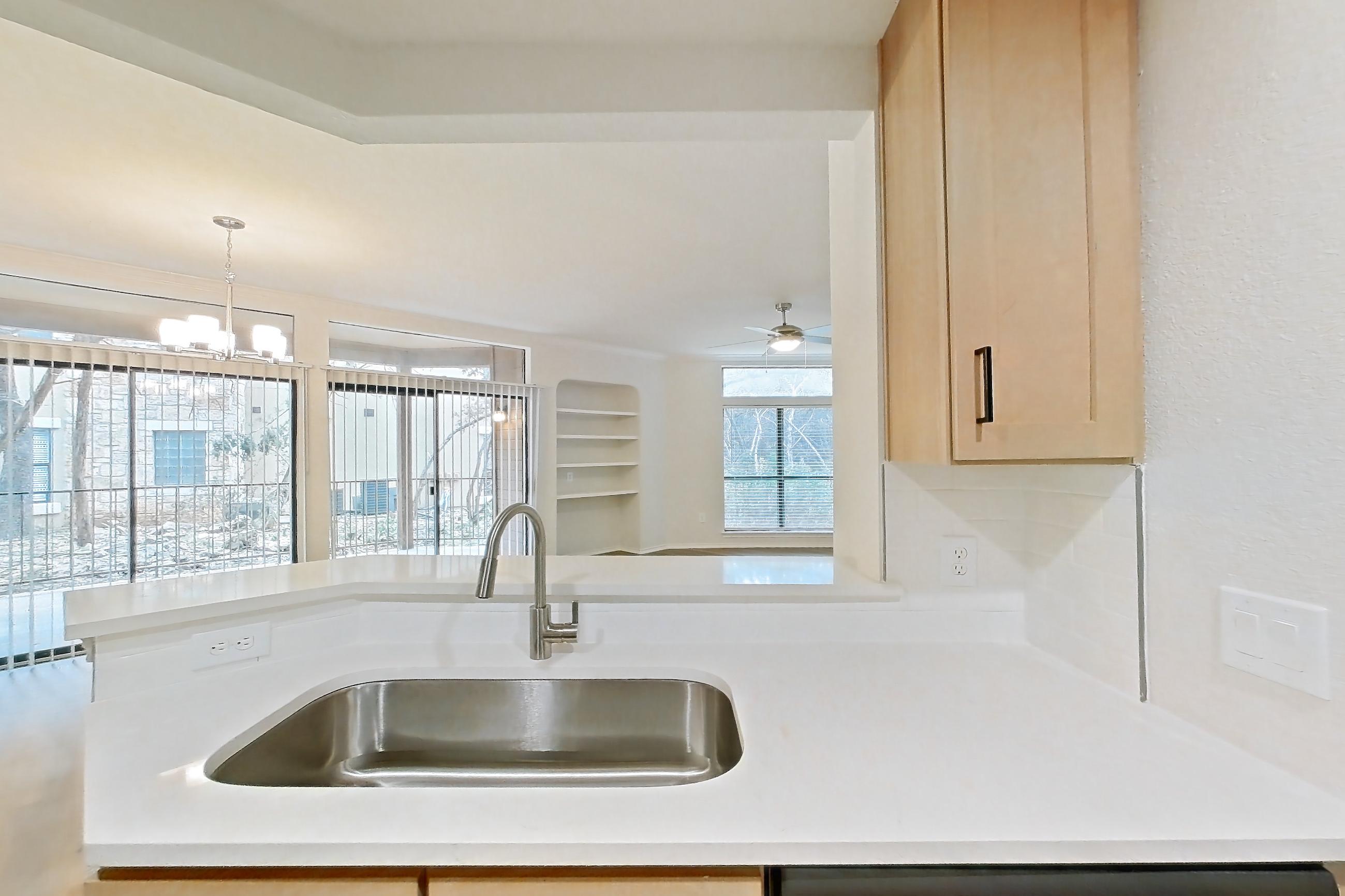 Kitchen with dishwasher, gas range, light butcher block countertops, light countertops, light wood-finish flooring, microwave, oven/range, refrigerator, and stainless steel appliances, Apartment 2701 at Marquis at Caprock Canyon