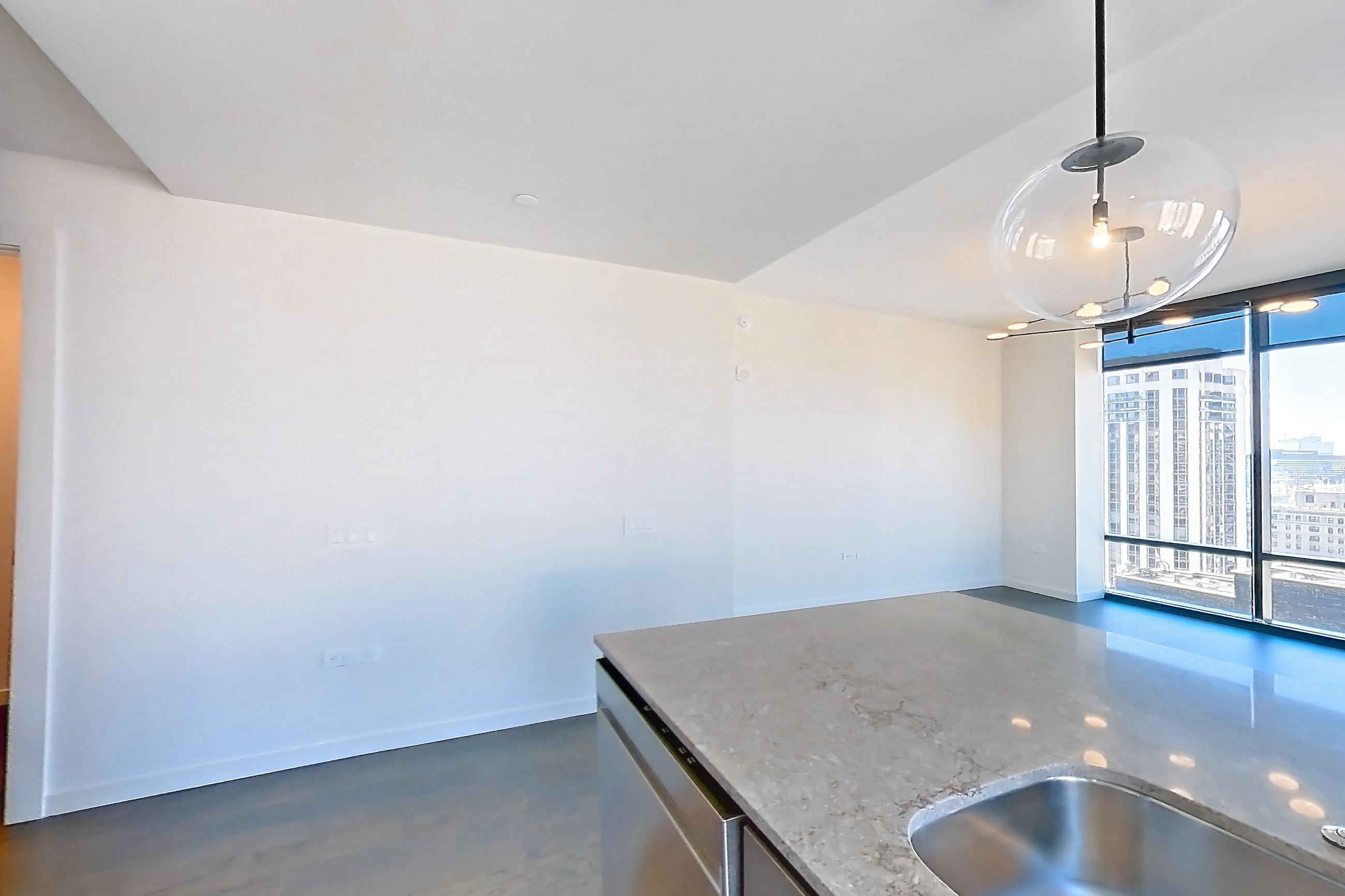 Kitchen with dark wood-finish flooring, dishwasher, electric range, kitchen island, light stone countertops, oven/range, and stainless steel appliances, Apartment 1909 at 1909 Rittenhouse