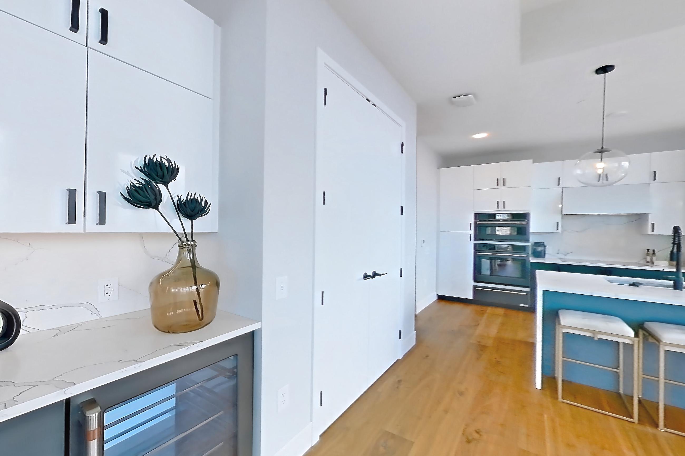 Dining room with black appliances, city view, kitchen island, light countertops, light stone countertops, light wood-finish flooring, oven/range, and wood-finish flooring, Apartment 2601 at Josephine