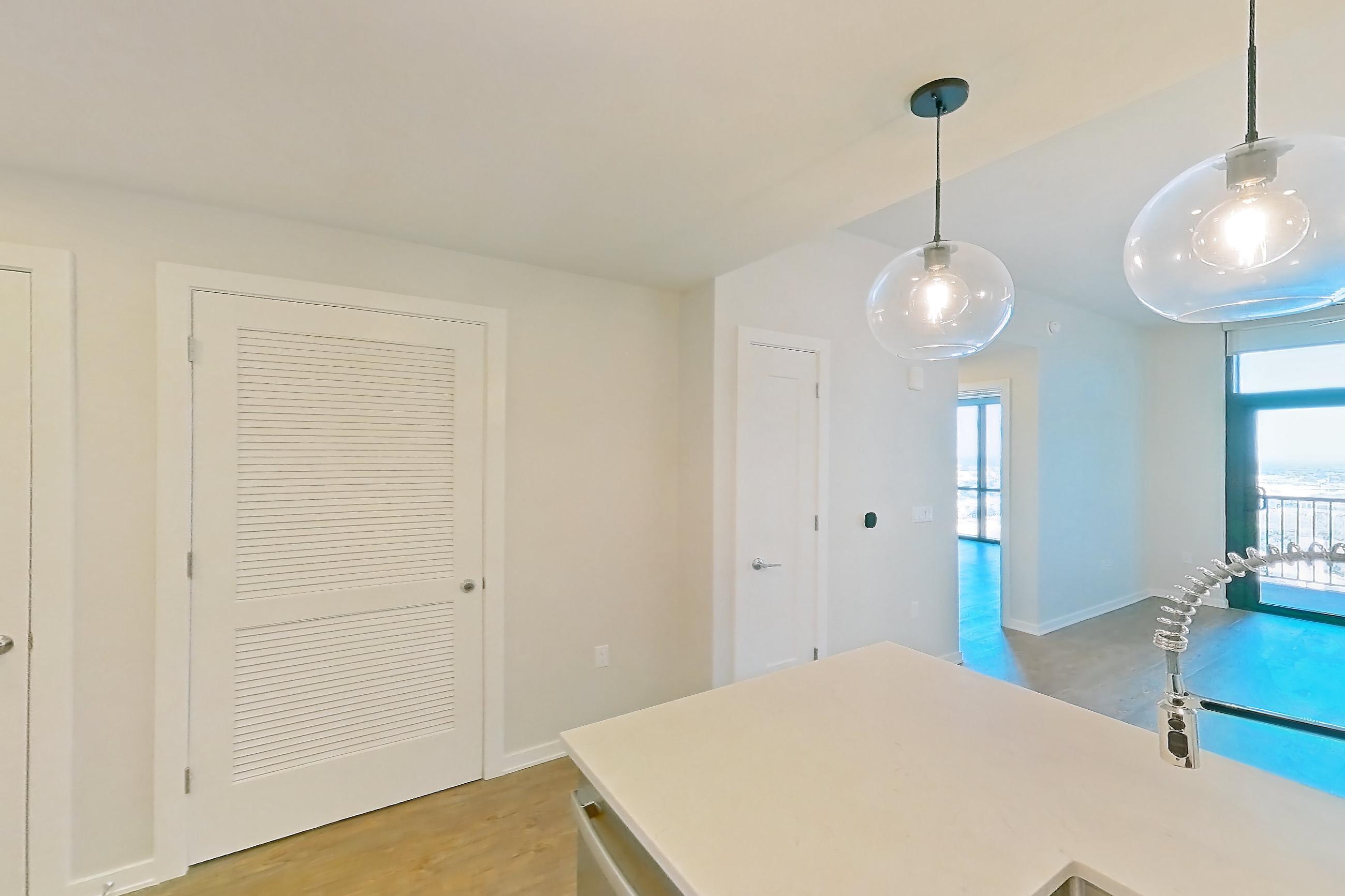 Kitchen with dishwasher, electric range, light countertops, light stone countertops, light wood-finish flooring, oven/range, range hood, and stainless steel appliances, Apartment 2017 at Deco 969
