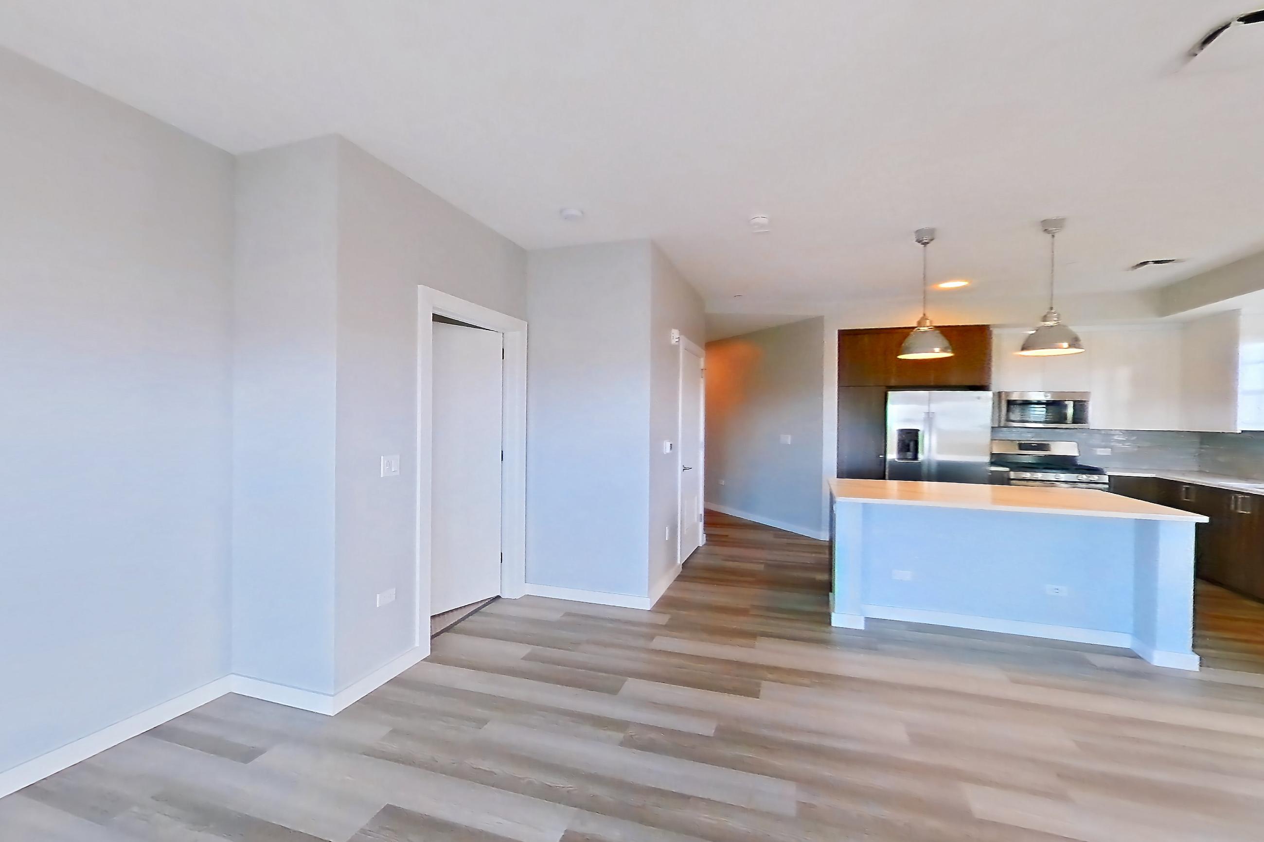 Living space with dishwasher, gas range, light countertops, light wood-finish flooring, oven/range, and stainless steel appliances, Apartment N416 at Carlow Wind Watch