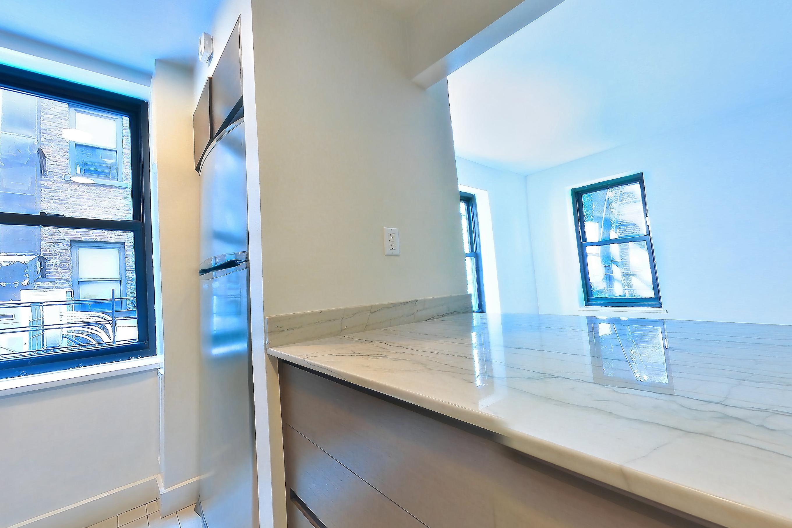 Kitchen with gas range, light stone countertops, light tile flooring, oven/range, and stainless steel appliances, Apartment N-2A at Stonehenge Leasing