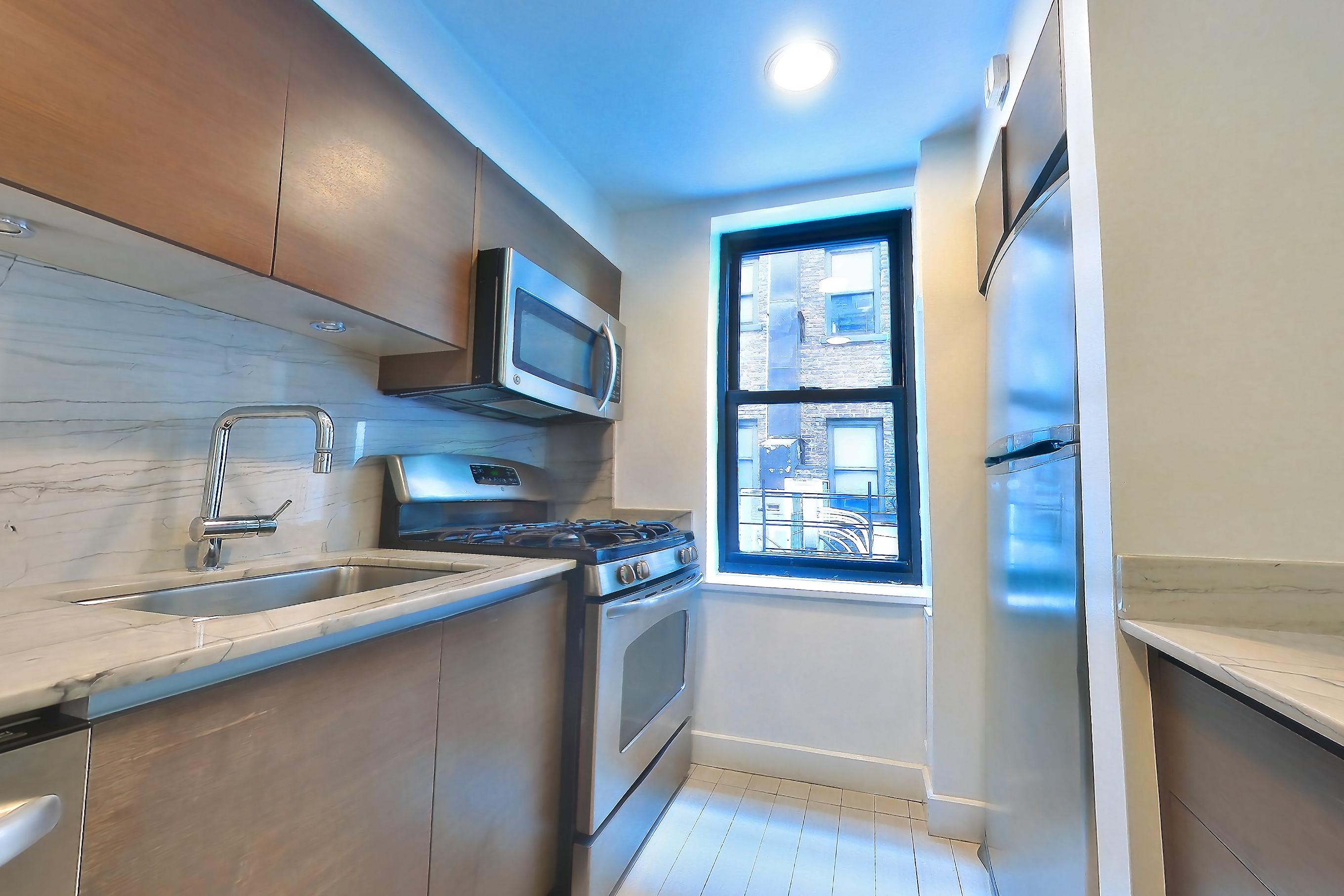 Kitchen with gas range, light stone countertops, light tile flooring, oven/range, and stainless steel appliances, Apartment N-2A at Stonehenge Leasing