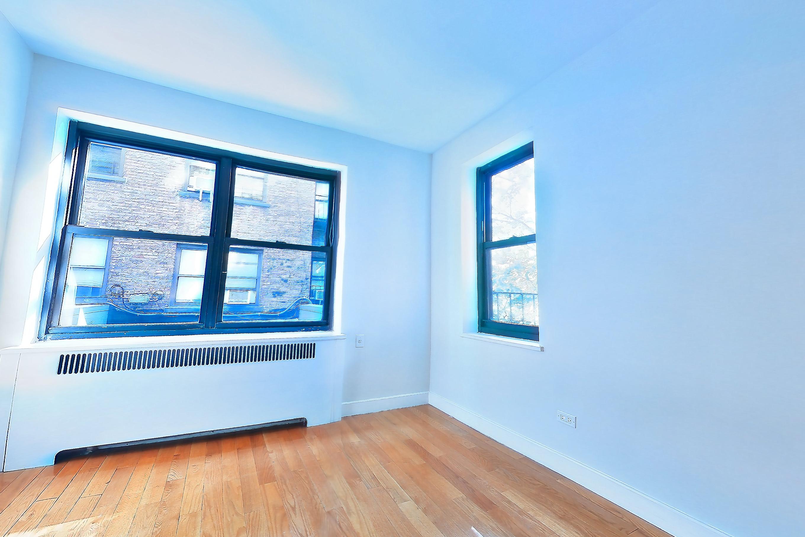 Living room with light wood-finish flooring and wood-finish flooring, Apartment N-2A at Stonehenge Leasing