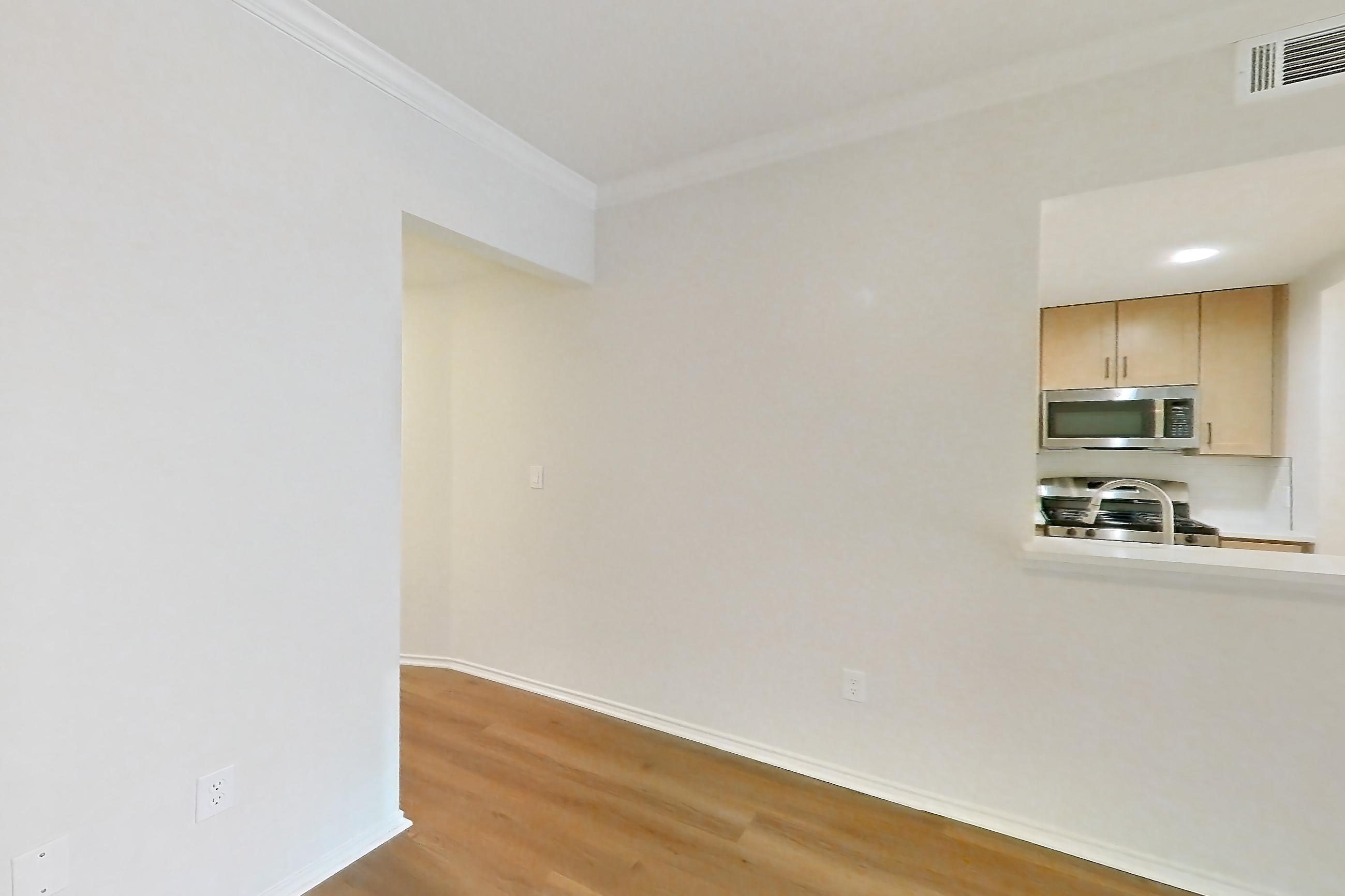 Living space with gas range, light wood-finish flooring, microwave, oven/range, and stainless steel appliances, Apartment 1805 at Marquis at Caprock Canyon