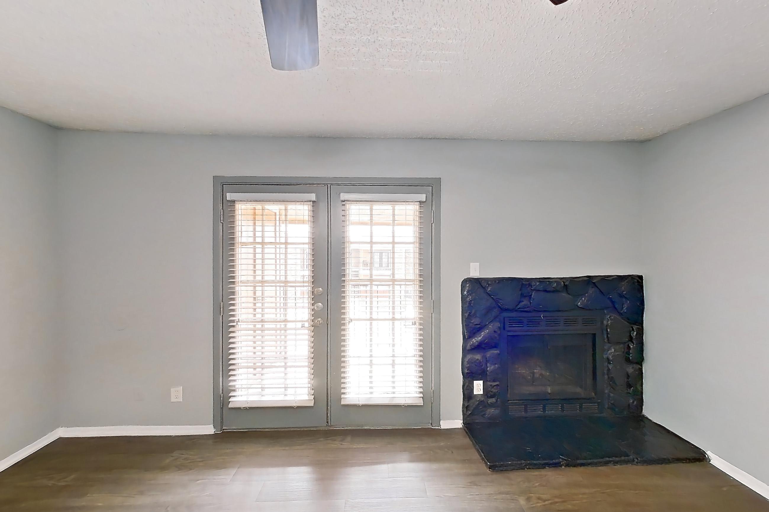 Living room with dark wood-finish flooring, fireplace, and stone fireplace, Apartment 106 at Marine Creek Apartments