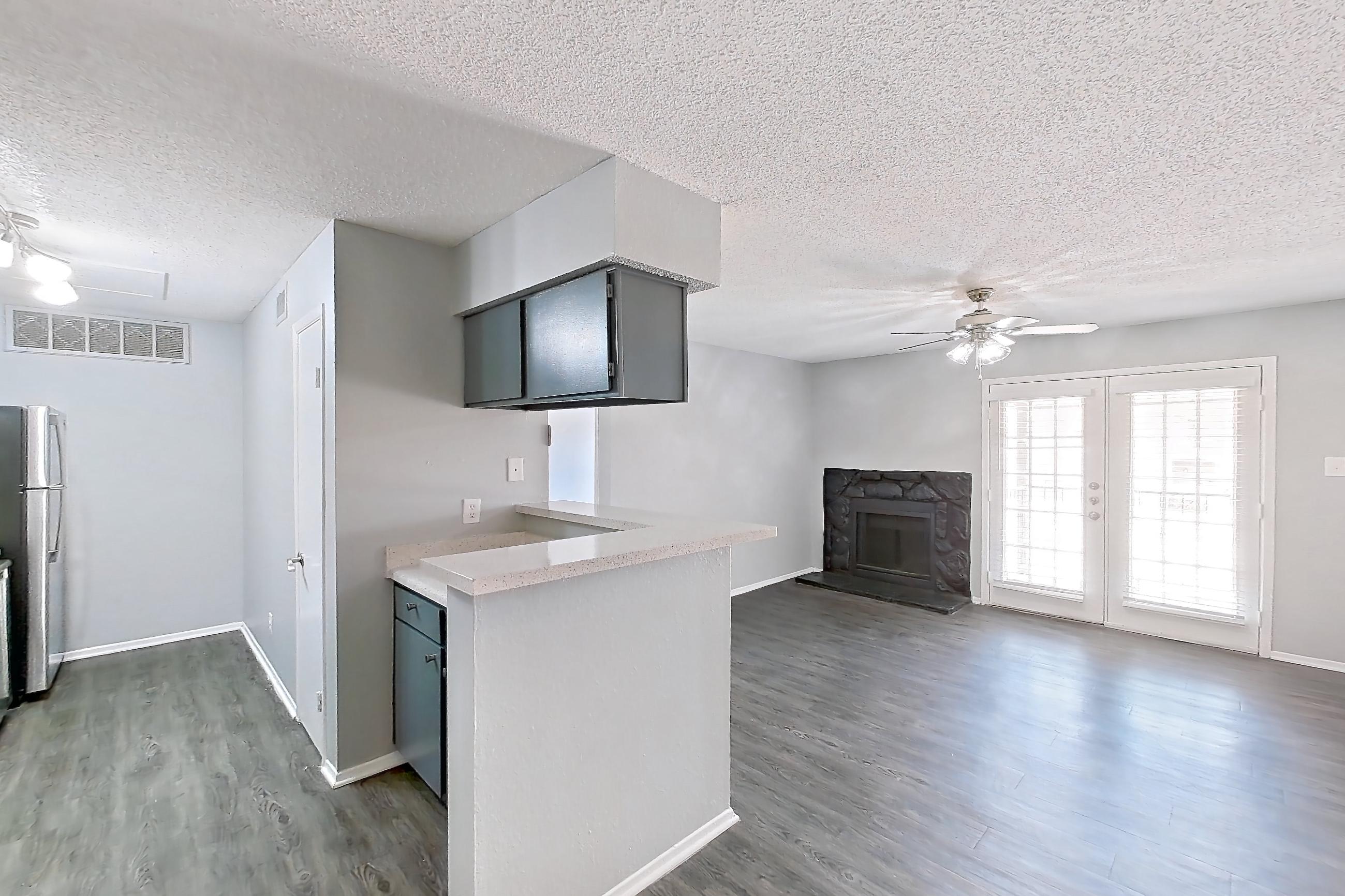 Dining room with dark wood-finish flooring, electric range, fireplace, light countertops, oven/range, stainless steel appliances, and stone fireplace, Apartment 502 at Marine Creek Apartments