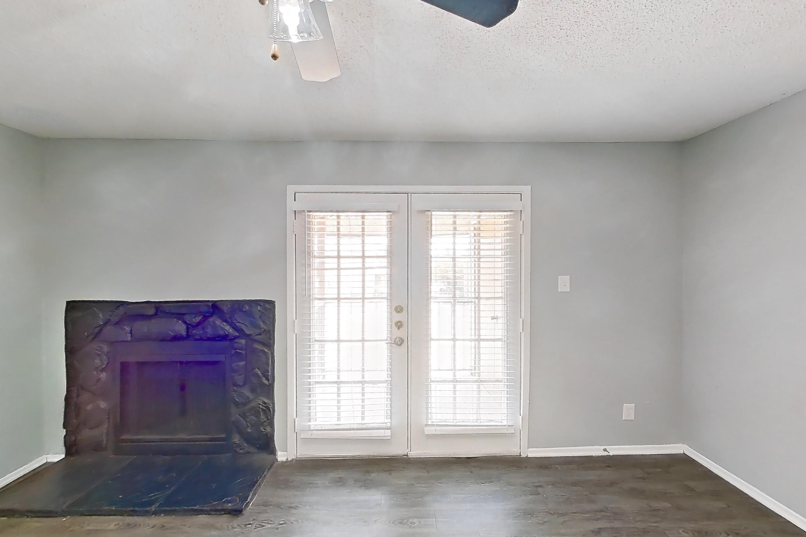 Living room with dark wood-finish flooring and fireplace, Apartment 502 at Marine Creek Apartments