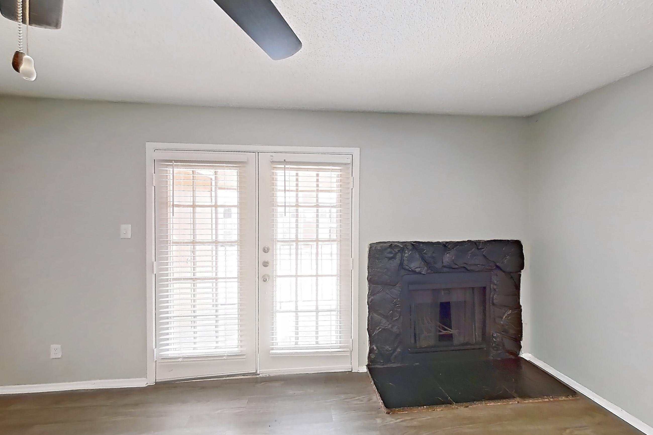 Living room with dark wood-finish flooring, fireplace, and stone fireplace, Apartment 508 at Marine Creek Apartments