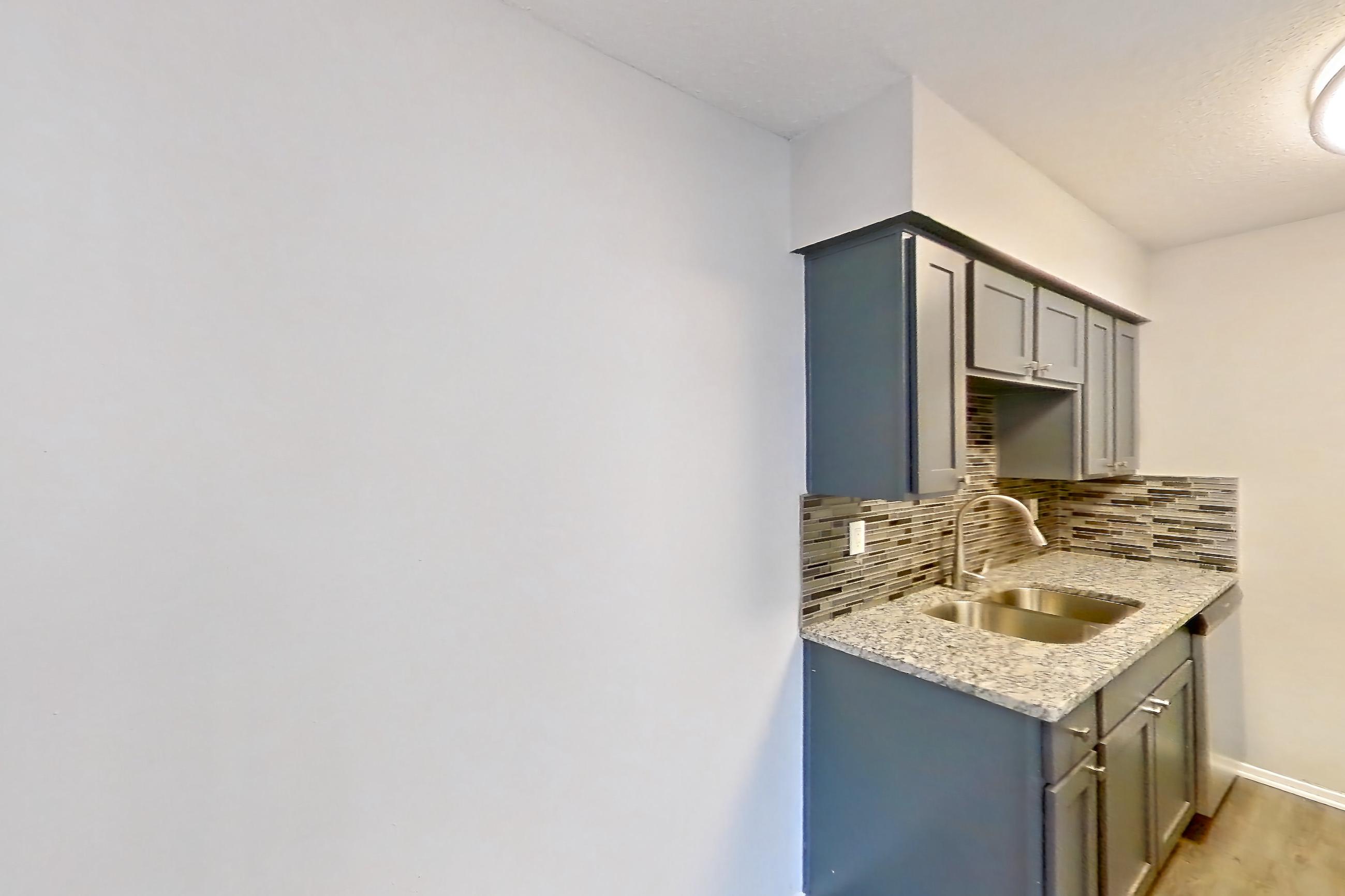 Dining room with dark wood-finish flooring, dishwasher, electric range, light stone countertops, oven/range, refrigerator, and stainless steel appliances, Apartment 603 at Marine Creek Apartments