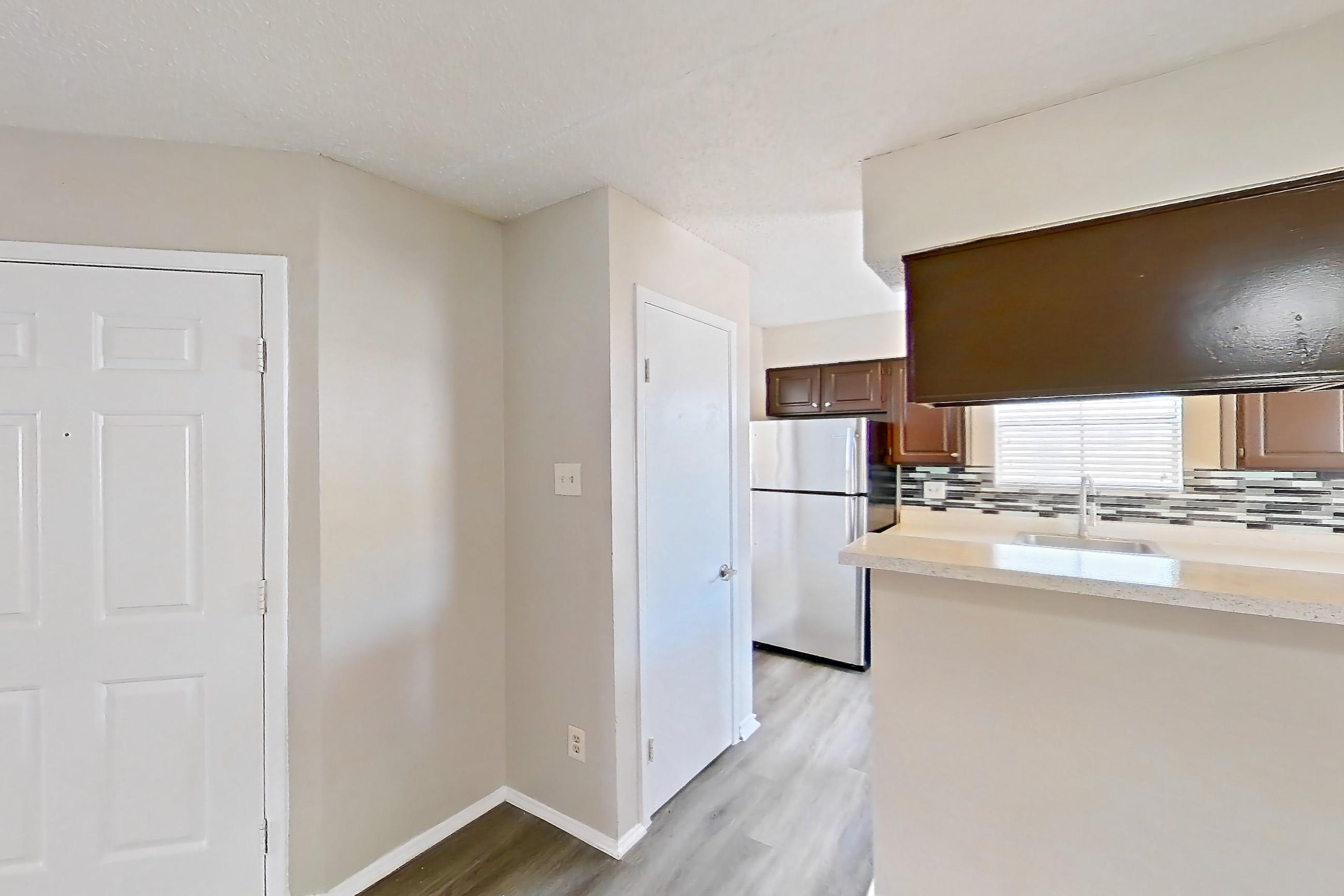Dining room with dark wood-finish flooring, refrigerator, and stainless steel appliances, Apartment 1606 at Marine Creek Apartments