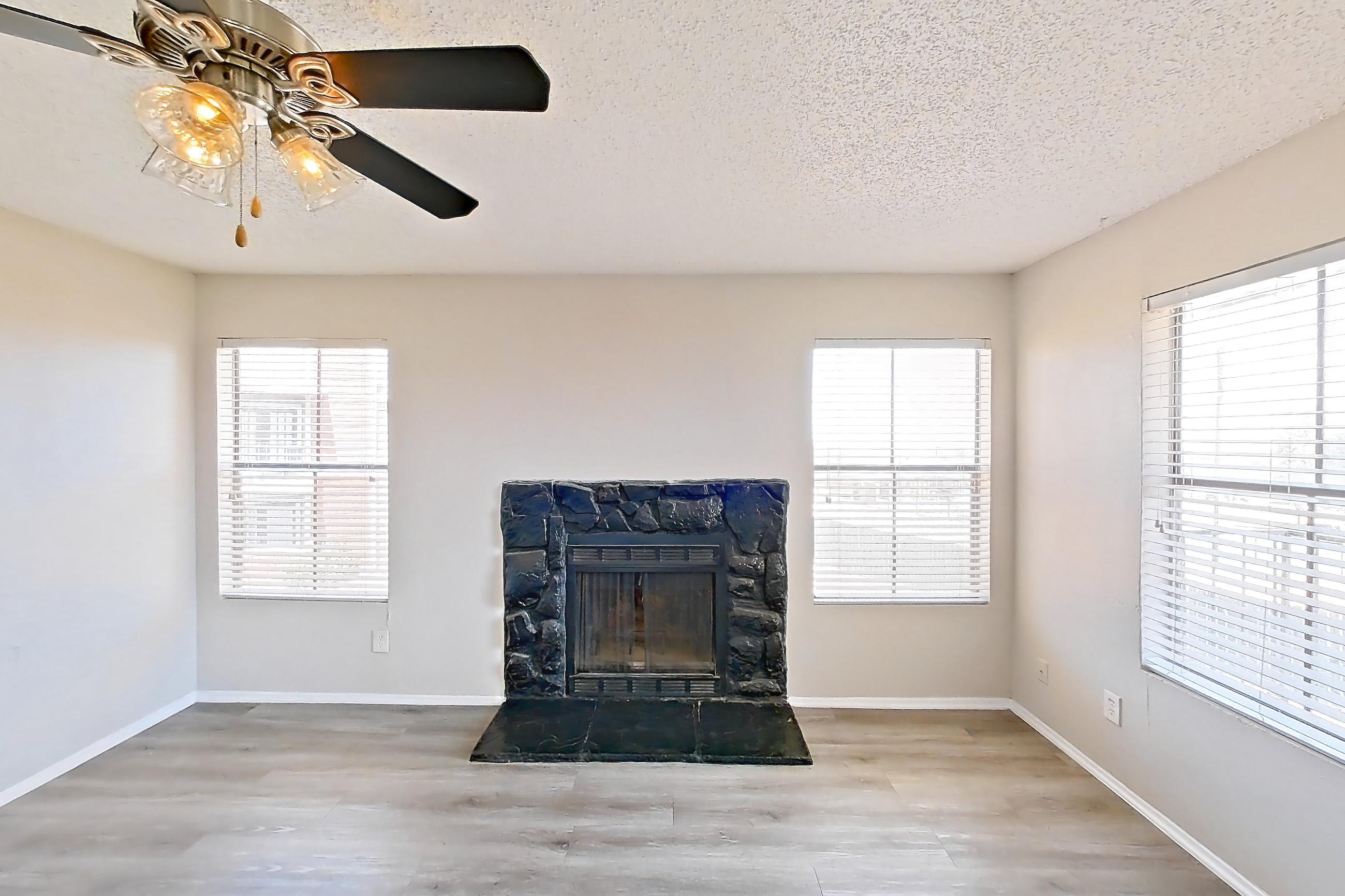 Living room with dark wood-finish flooring, fireplace, light wood-finish flooring, and tile fireplace, Apartment 1606 at Marine Creek Apartments