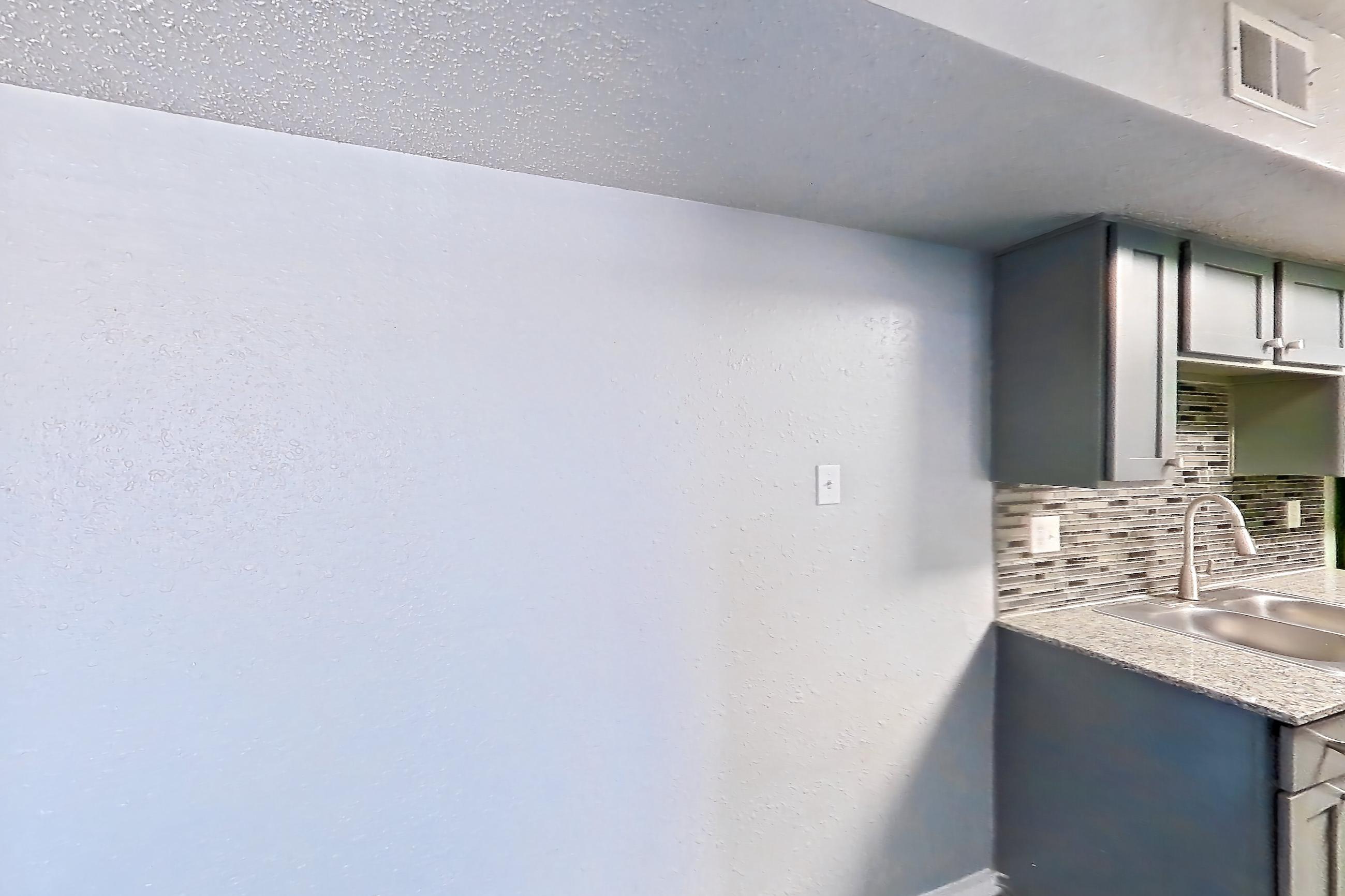 Dining room with dark wood-finish flooring, dishwasher, electric range, fireplace, light countertops, light stone countertops, light wood-finish flooring, oven/range, stainless steel appliances, and stone fireplace, Apartment 1801 at Marine Creek Apartments