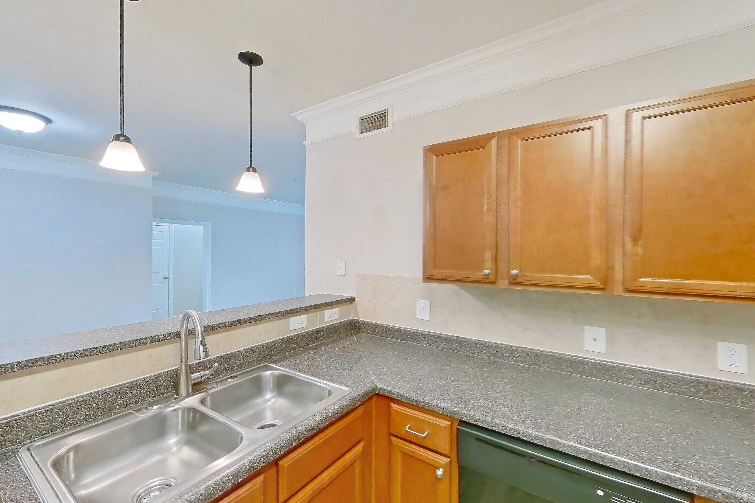 Kitchen with black appliances, dark countertops, dark wood-finish flooring, dishwasher, electric range, oven/range, refrigerator, and stainless steel appliances, Apartment 3101 at Terraces at Fall Creek