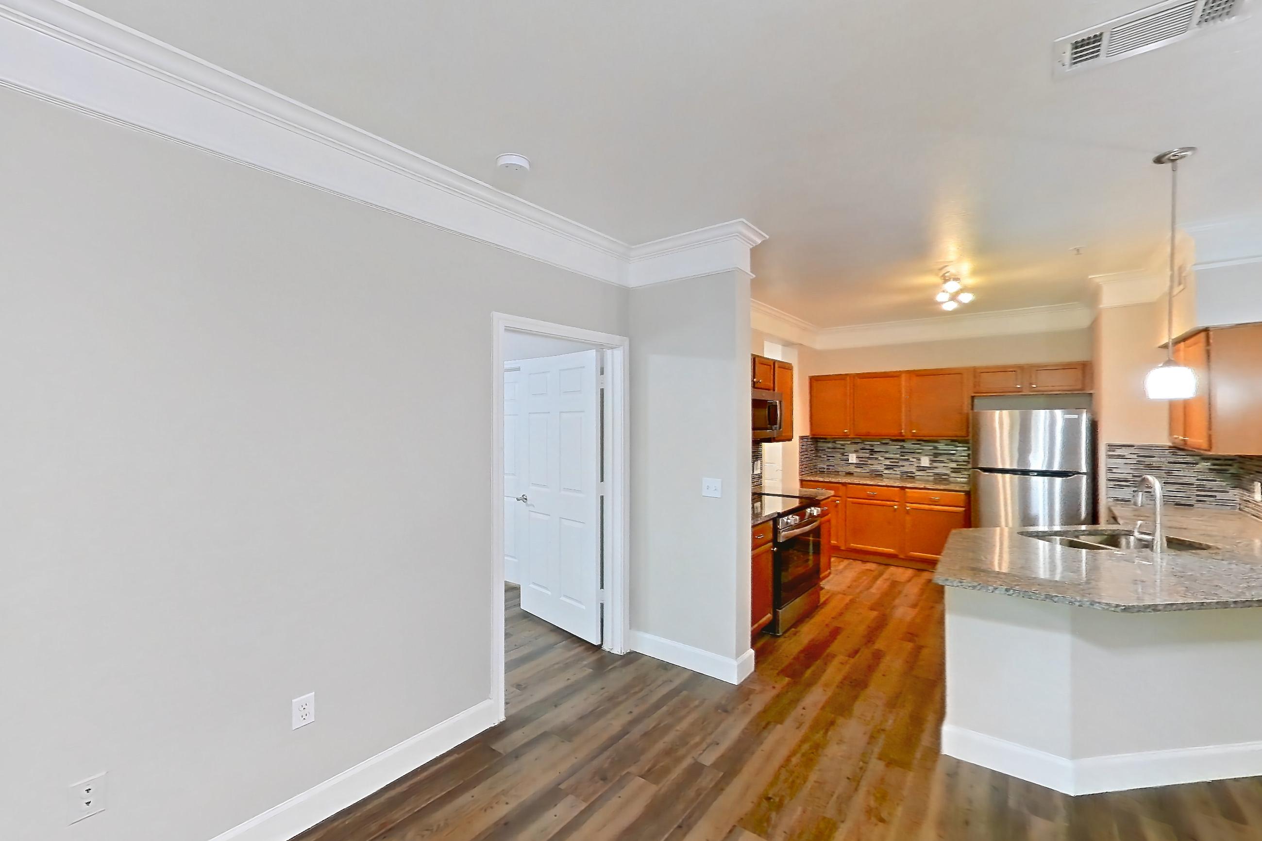 Living room with dark wood-finish flooring, electric range, kitchen island, oven/range, refrigerator, and stainless steel appliances, Apartment 10108 at Terraces at Fall Creek