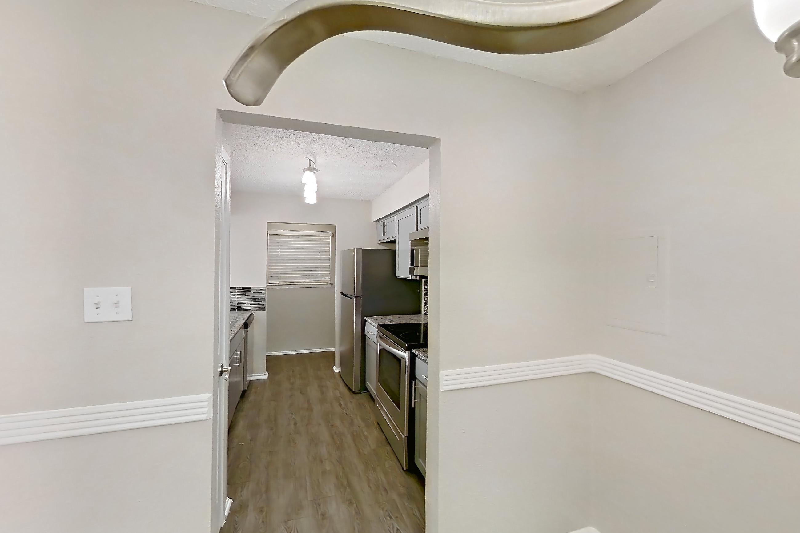 Dining room with dark wood-finish flooring, electric range, oven/range, refrigerator, and stainless steel appliances, Apartment 236ND at The Cassidy at Western Hills
