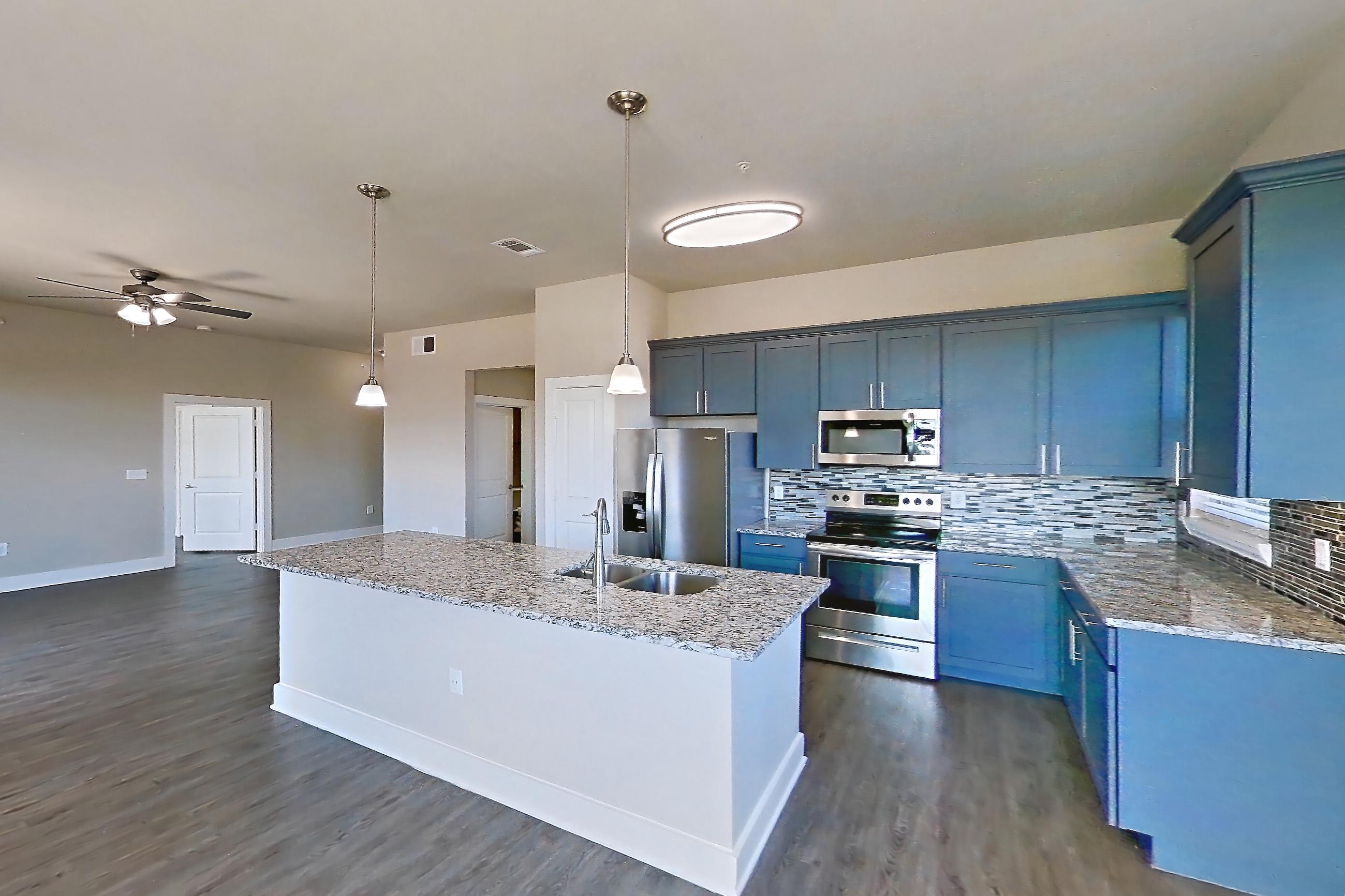 Dining room with dark wood-finish flooring, electric range, light countertops, light stone countertops, oven/range, refrigerator, stainless steel appliances, and water & ice dispenser, Apartment 356 at Voyager at the Space Center