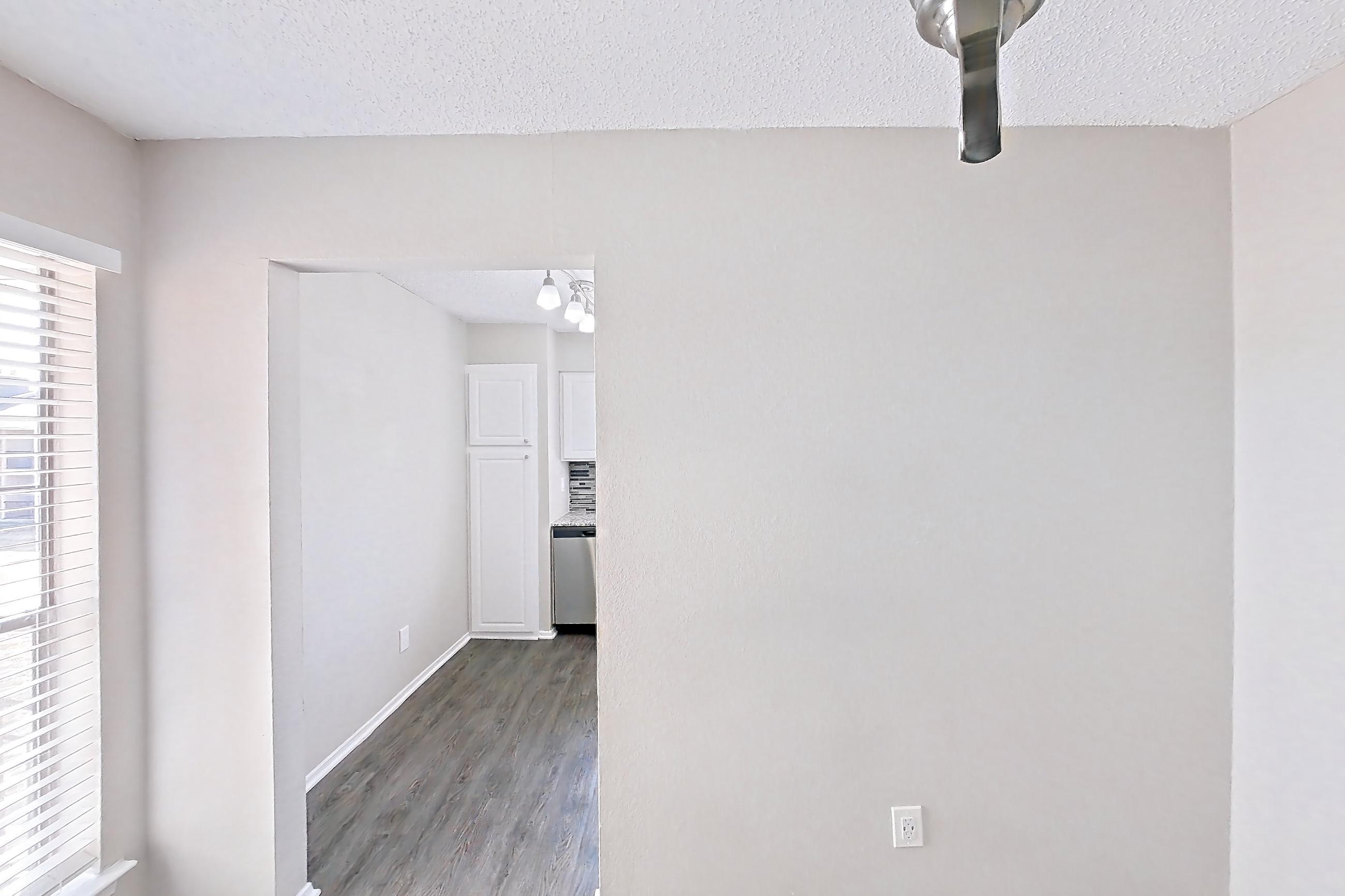 Dining room with dark wood-finish flooring, dishwasher, and stainless steel appliances, Apartment 2181 at Creekside Village