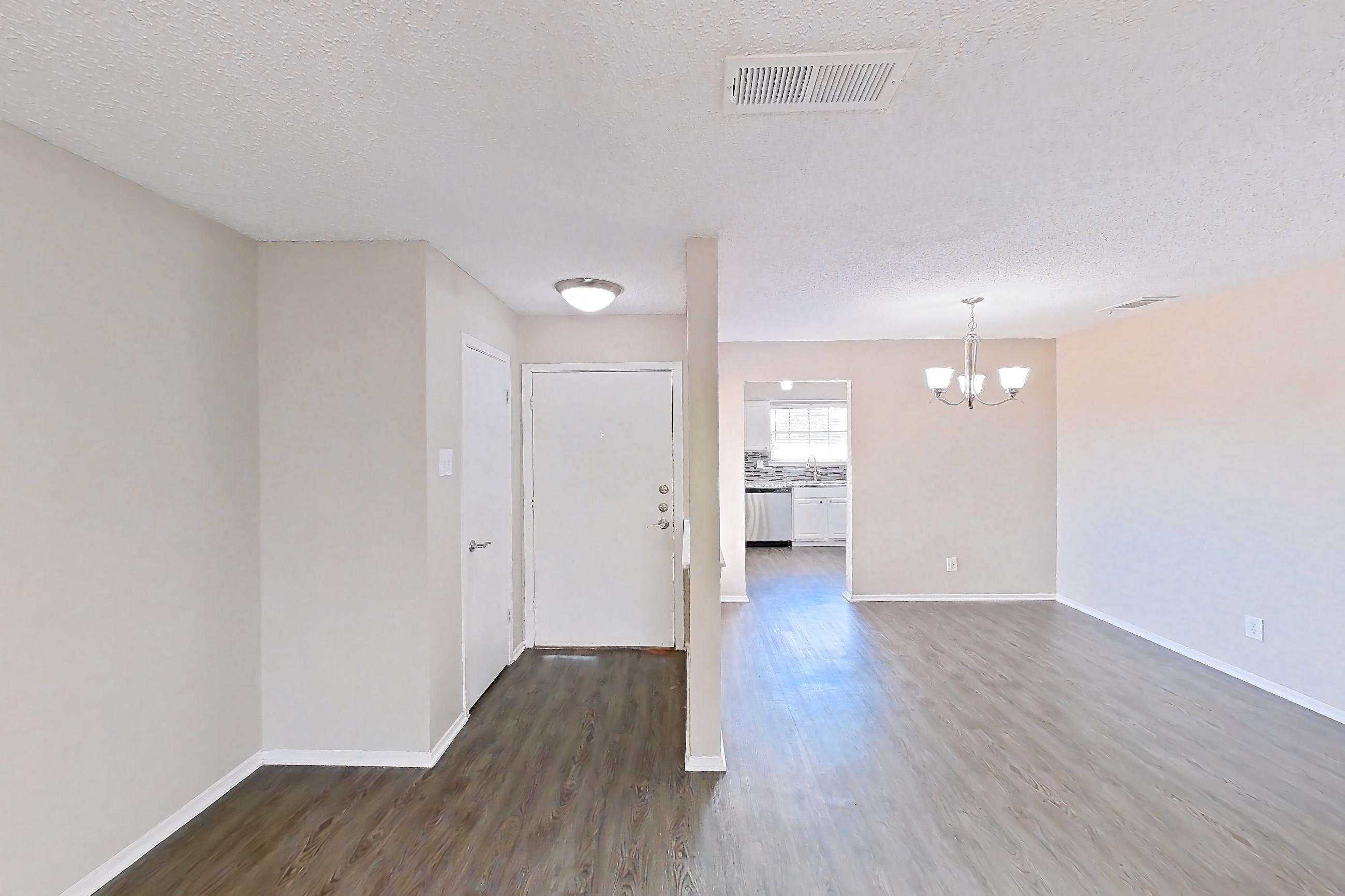 Living room with dark wood-finish flooring, dishwasher, fireplace, and stainless steel appliances, Apartment 2181 at Creekside Village