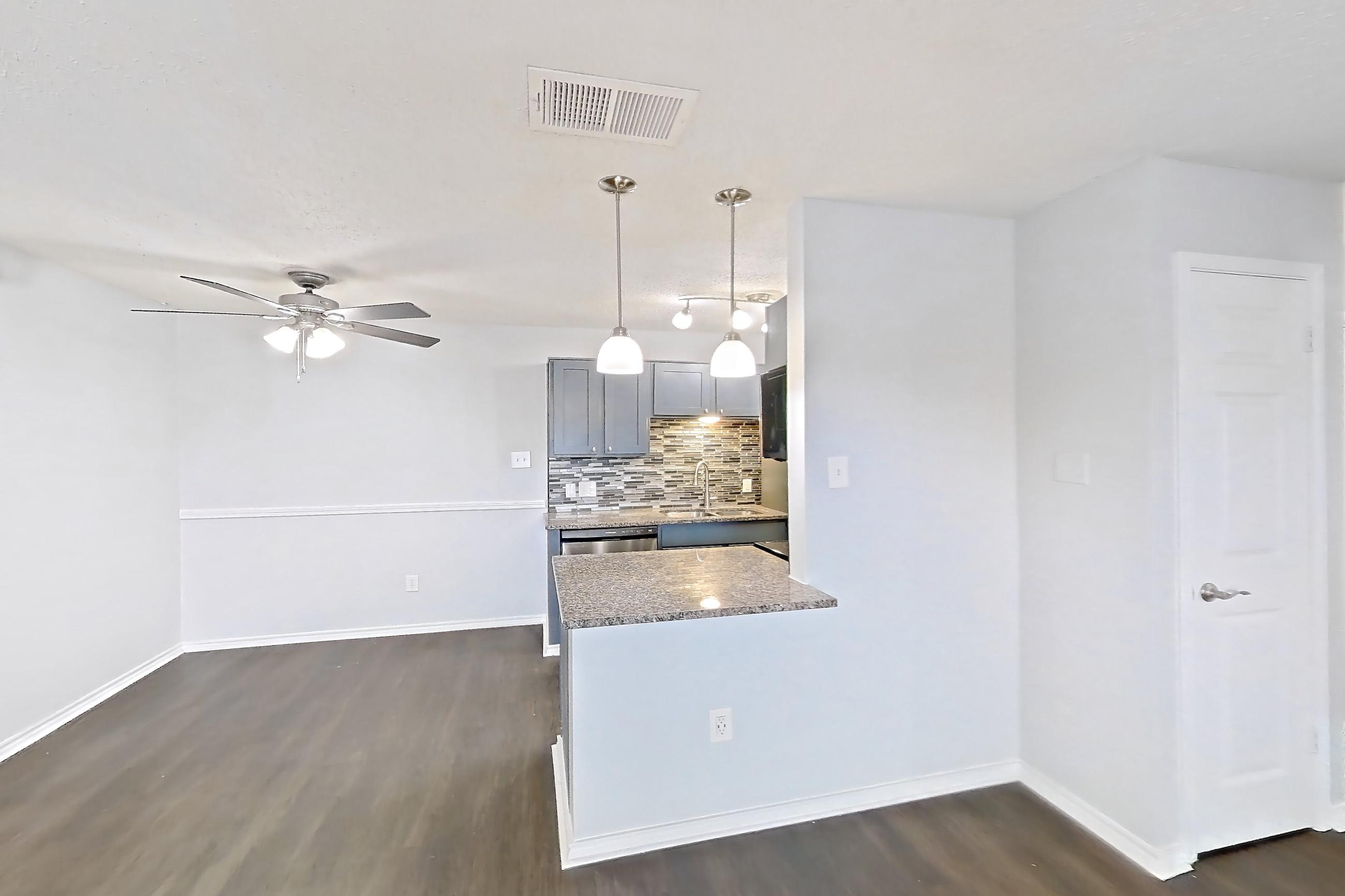 Living room with dark wood-finish flooring, dishwasher, fireplace, and stainless steel appliances, Apartment 506 at Quail Ridge Apartments