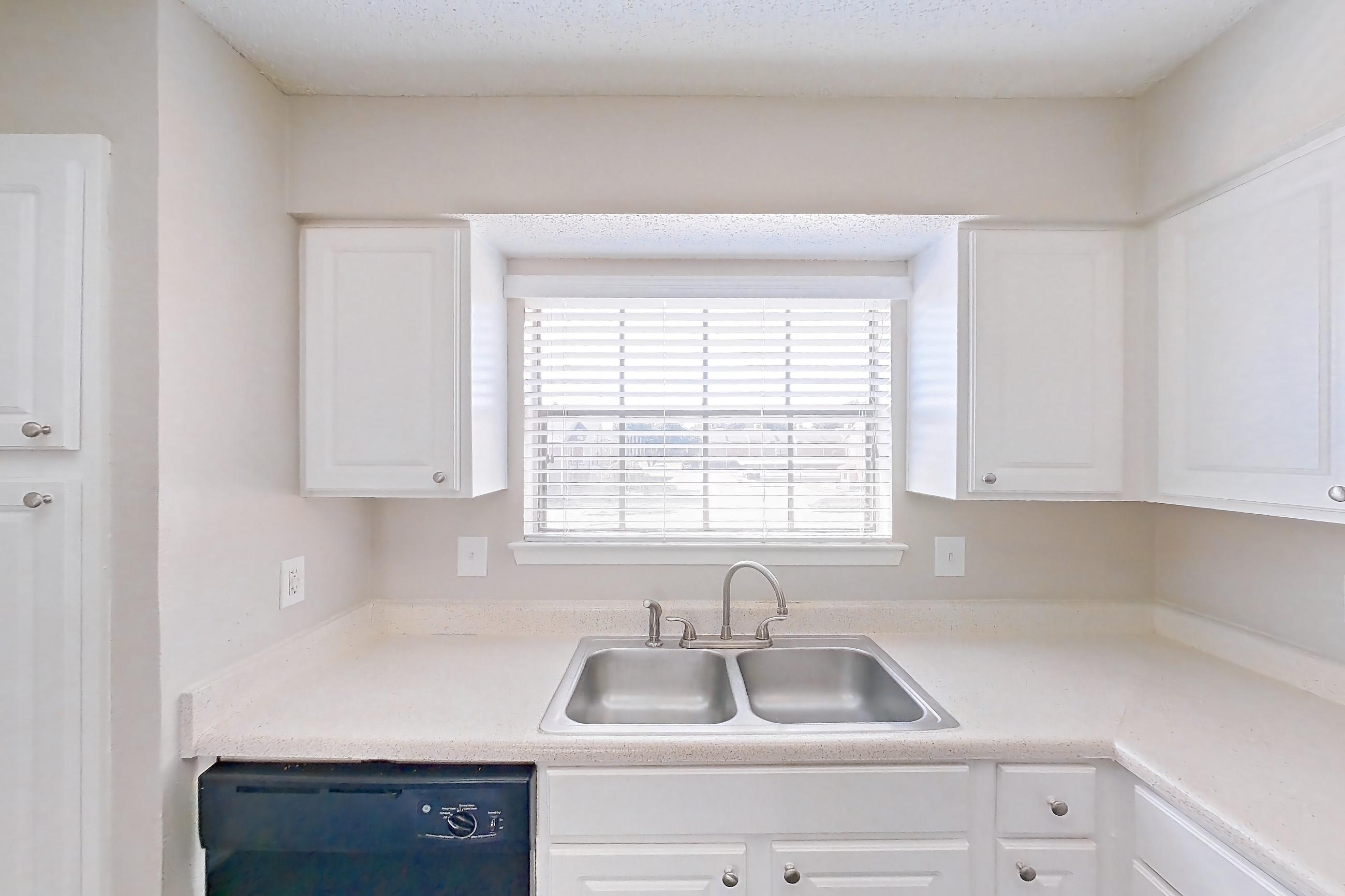 Kitchen with black appliances, dishwasher, electric range, light countertops, light wood-finish flooring, oven/range, range hood, and refrigerator, Apartment 2219 at Creekside Village