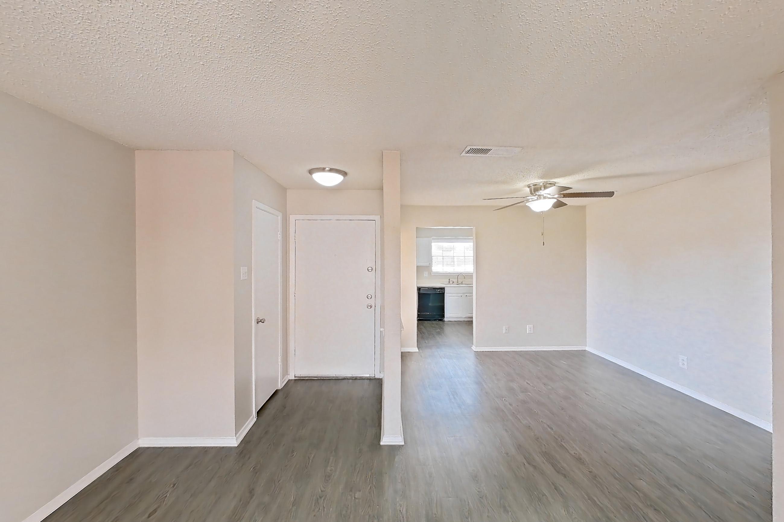 Living room with black appliances, dark wood-finish flooring, dishwasher, and fireplace, Apartment 2219 at Creekside Village
