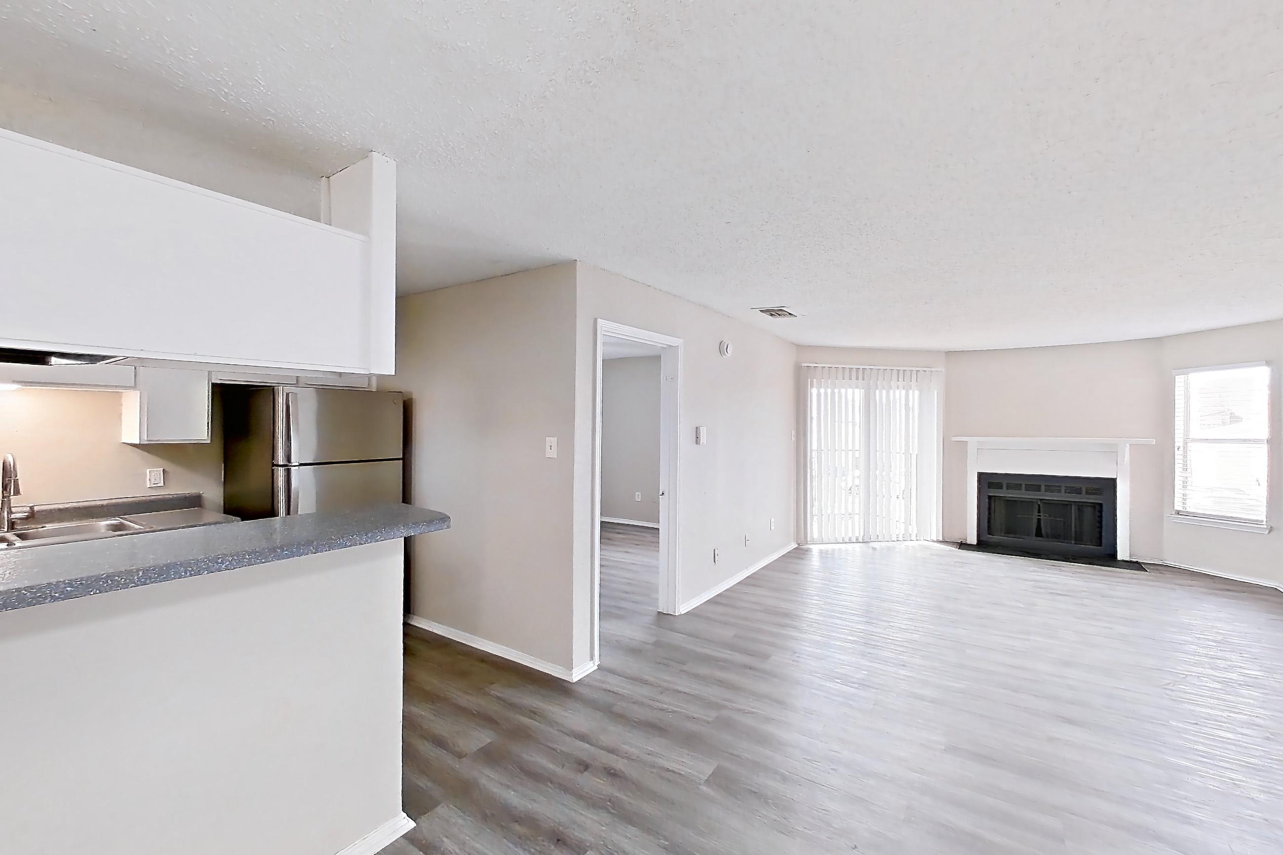 Dining room with dark wood-finish flooring, fireplace, light wood-finish flooring, mini-split AC, refrigerator, and stainless steel appliances, Apartment 1904 at Quail Ridge Apartments