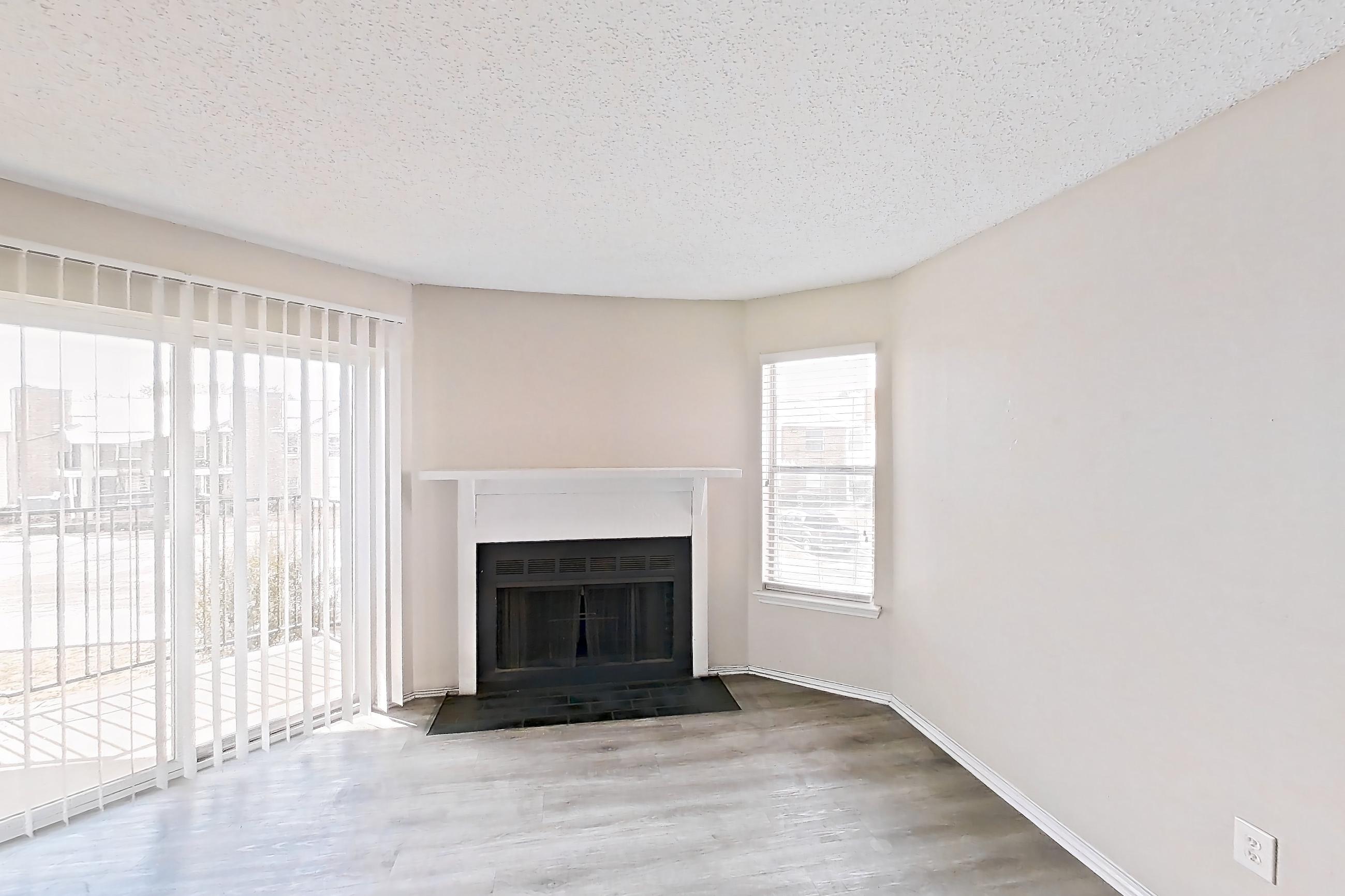 Living room with fireplace and light wood-finish flooring, Apartment 1904 at Quail Ridge Apartments