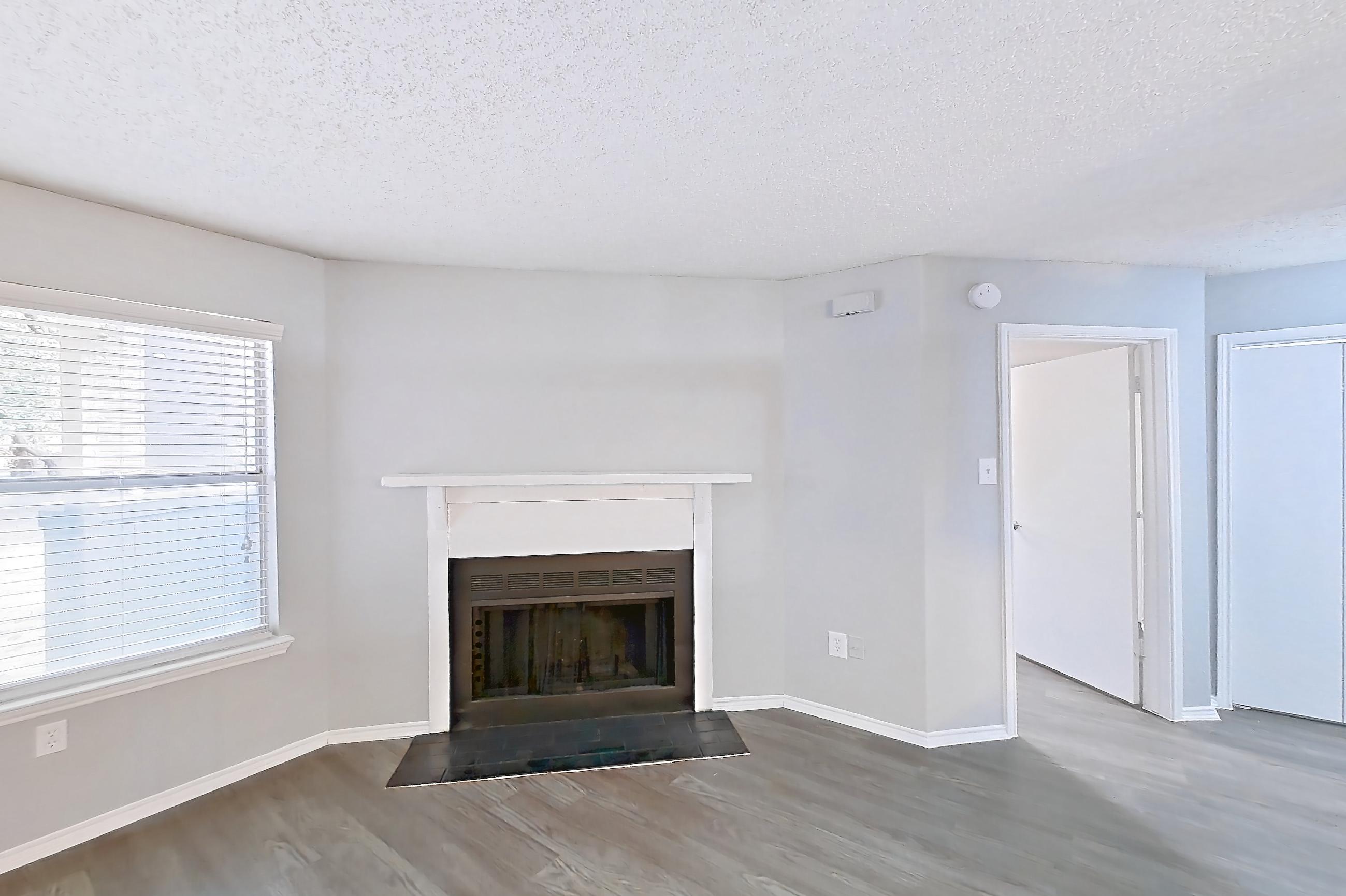 Living room with dark wood-finish flooring, fireplace, light countertops, and light wood-finish flooring, Apartment 2105 at Quail Ridge Apartments