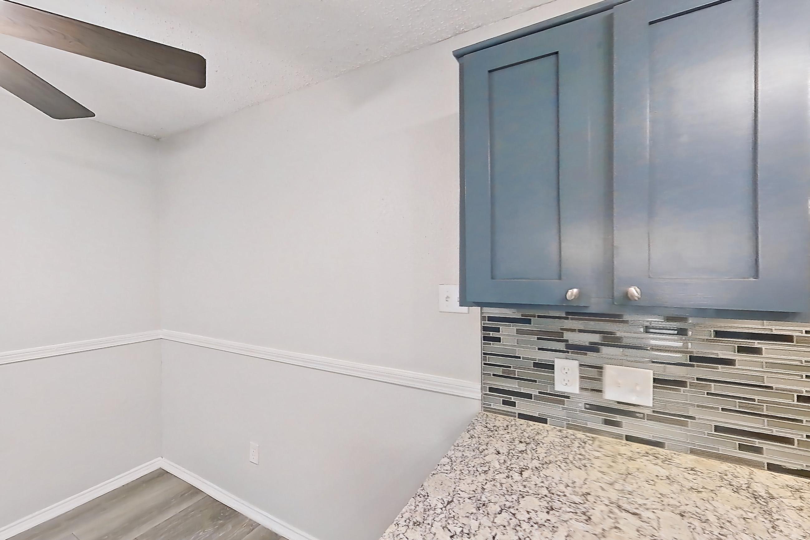 Kitchen with dishwasher, electric range, fireplace, light countertops, light stone countertops, light wood-finish flooring, oven/range, refrigerator, and stainless steel appliances, Apartment 2302 at Quail Ridge Apartments