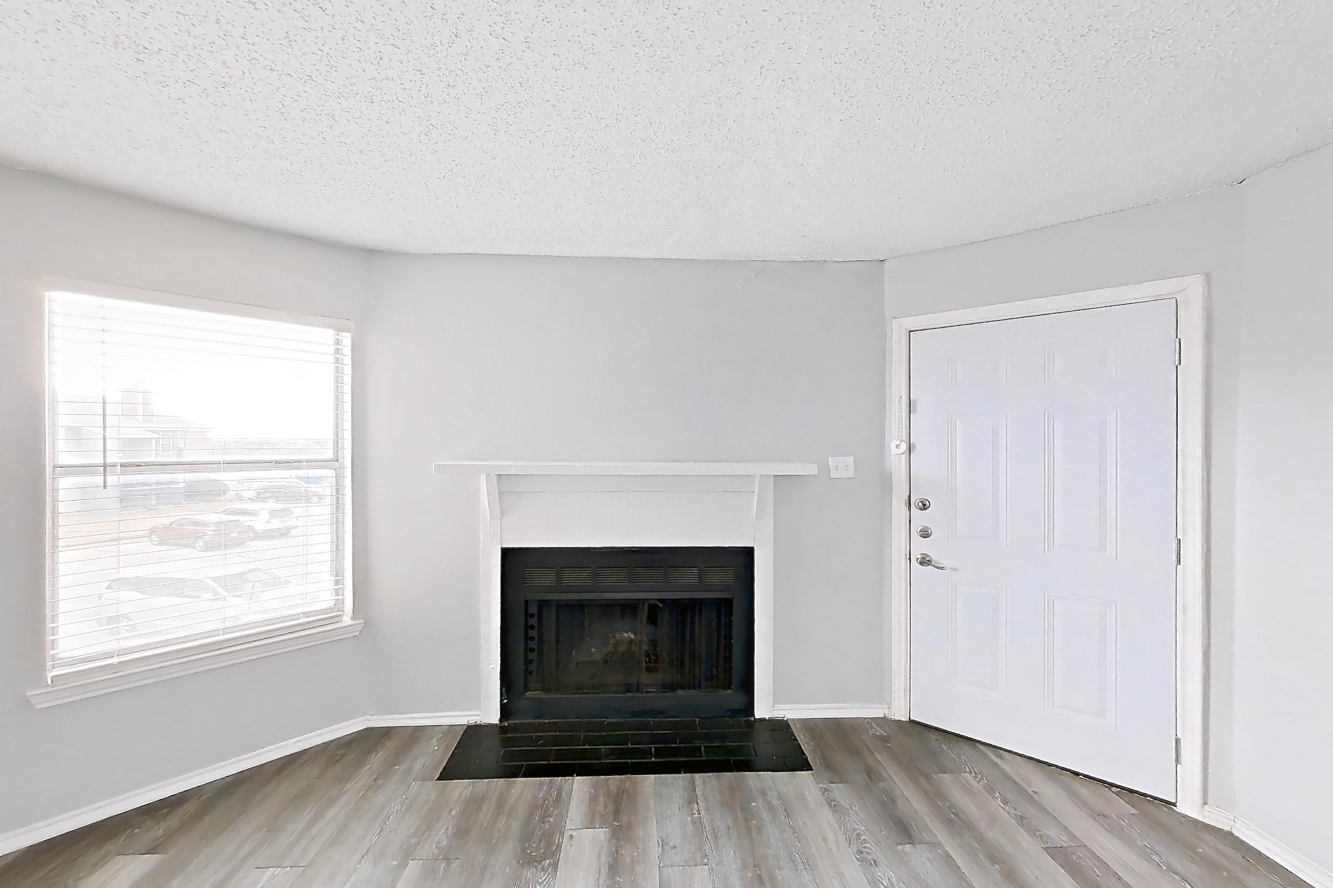 Living room with fireplace and light wood-finish flooring, Apartment 2302 at Quail Ridge Apartments