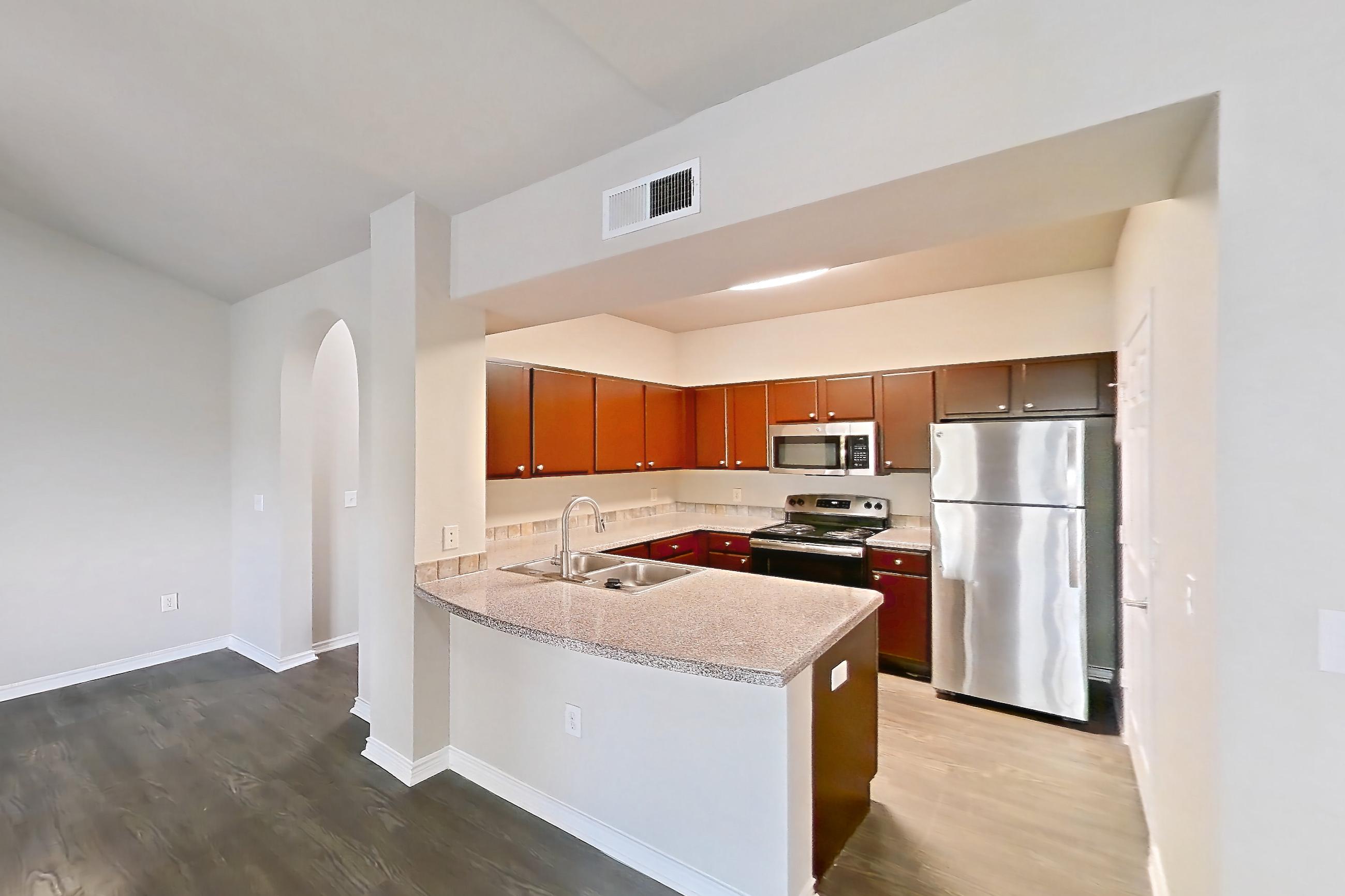 Living space with dark wood-finish flooring, electric range, light countertops, oven/range, refrigerator, and stainless steel appliances, Apartment 0232 at Residences at River Park West