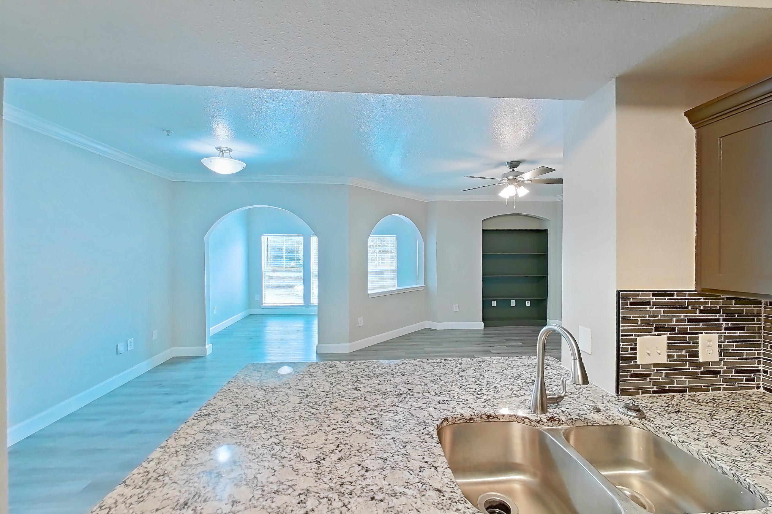 Kitchen with dishwasher, electric range, light stone countertops, light wood-finish flooring, oven/range, and stainless steel appliances, Apartment 0922 at Residences at River Park West