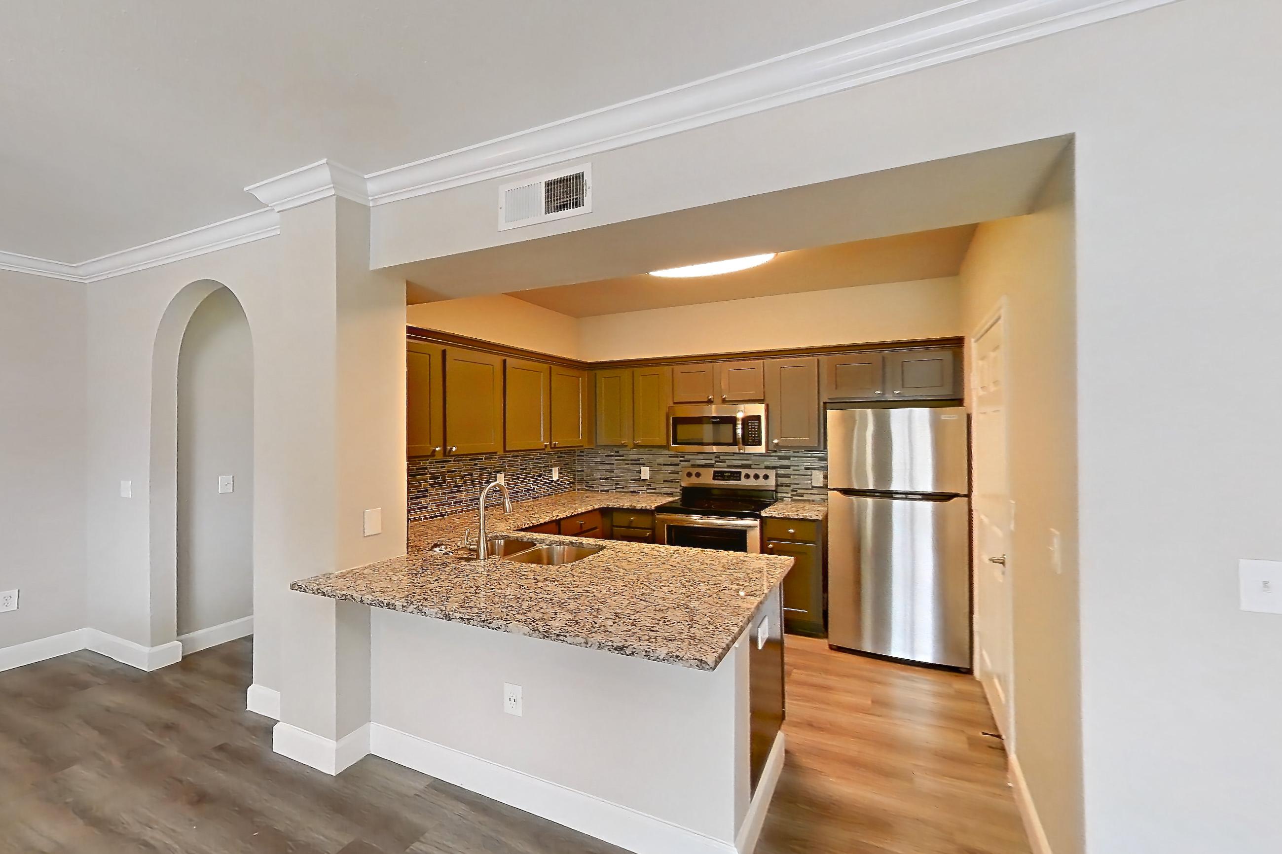 Living space with electric range, light stone countertops, light wood-finish flooring, oven/range, refrigerator, and stainless steel appliances, Apartment 0922 at Residences at River Park West