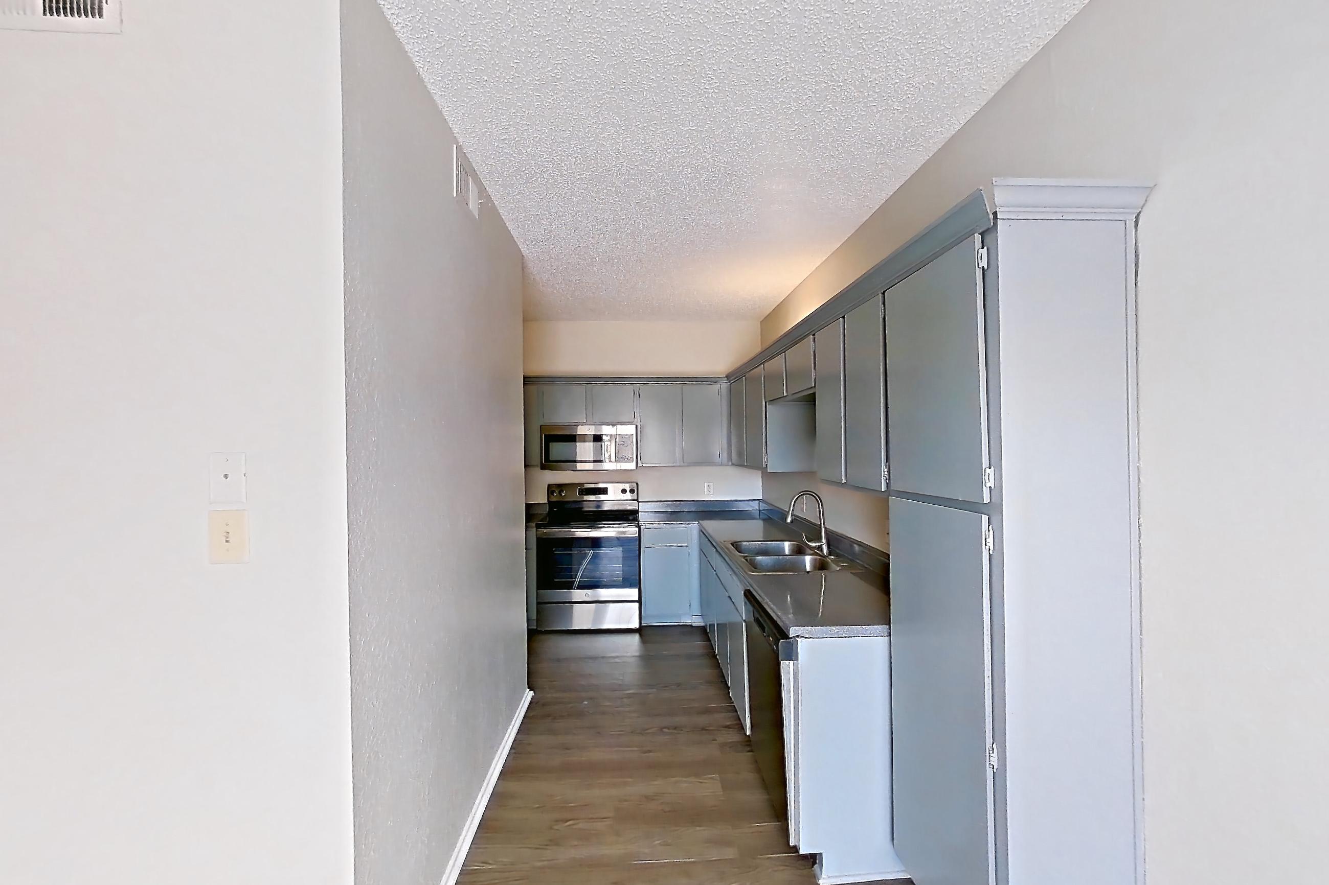 Dining room with dark countertops, dark wood-finish flooring, dishwasher, electric range, oven/range, and stainless steel appliances, Apartment 0123 at Waterford on the Meadow