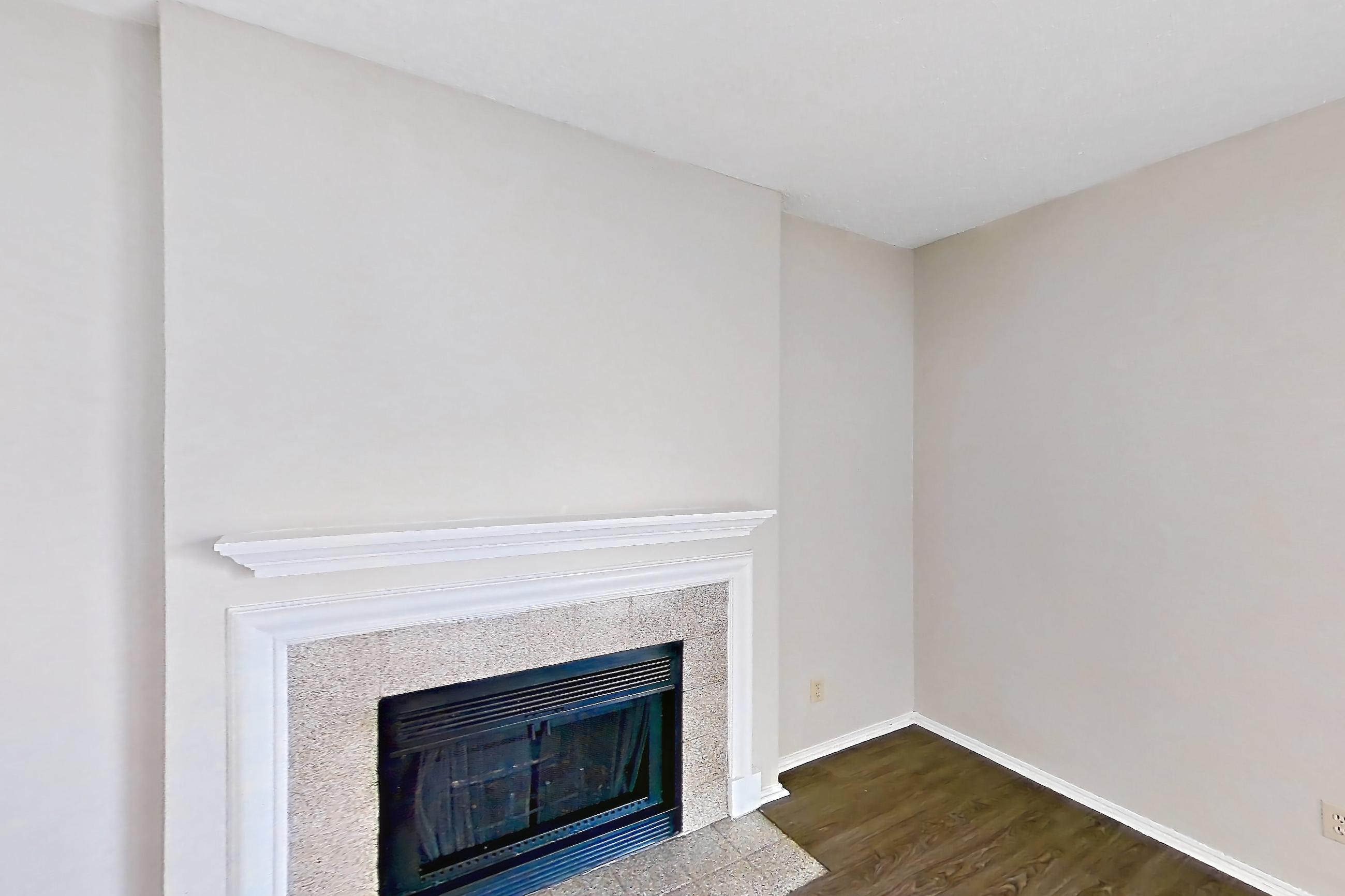 Living room with dark wood-finish flooring and fireplace, Apartment 0123 at Waterford on the Meadow