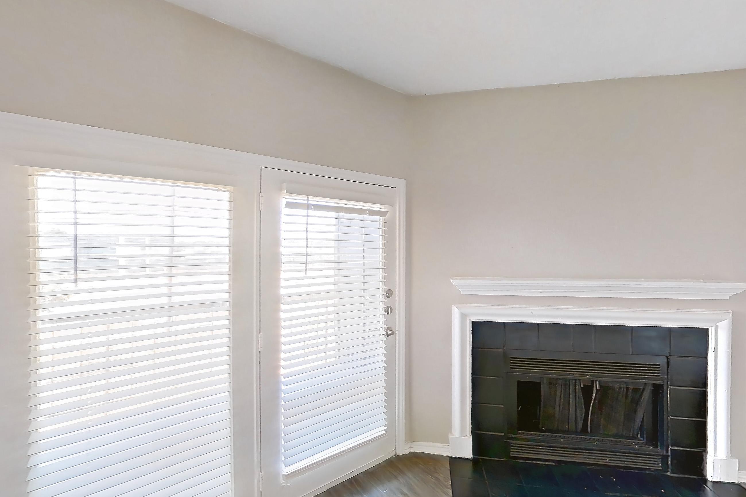 Living room with dark wood-finish flooring, electric range, fireplace, oven/range, refrigerator, stainless steel appliances, and tile fireplace, Apartment 1522 at Waterford on the Meadow