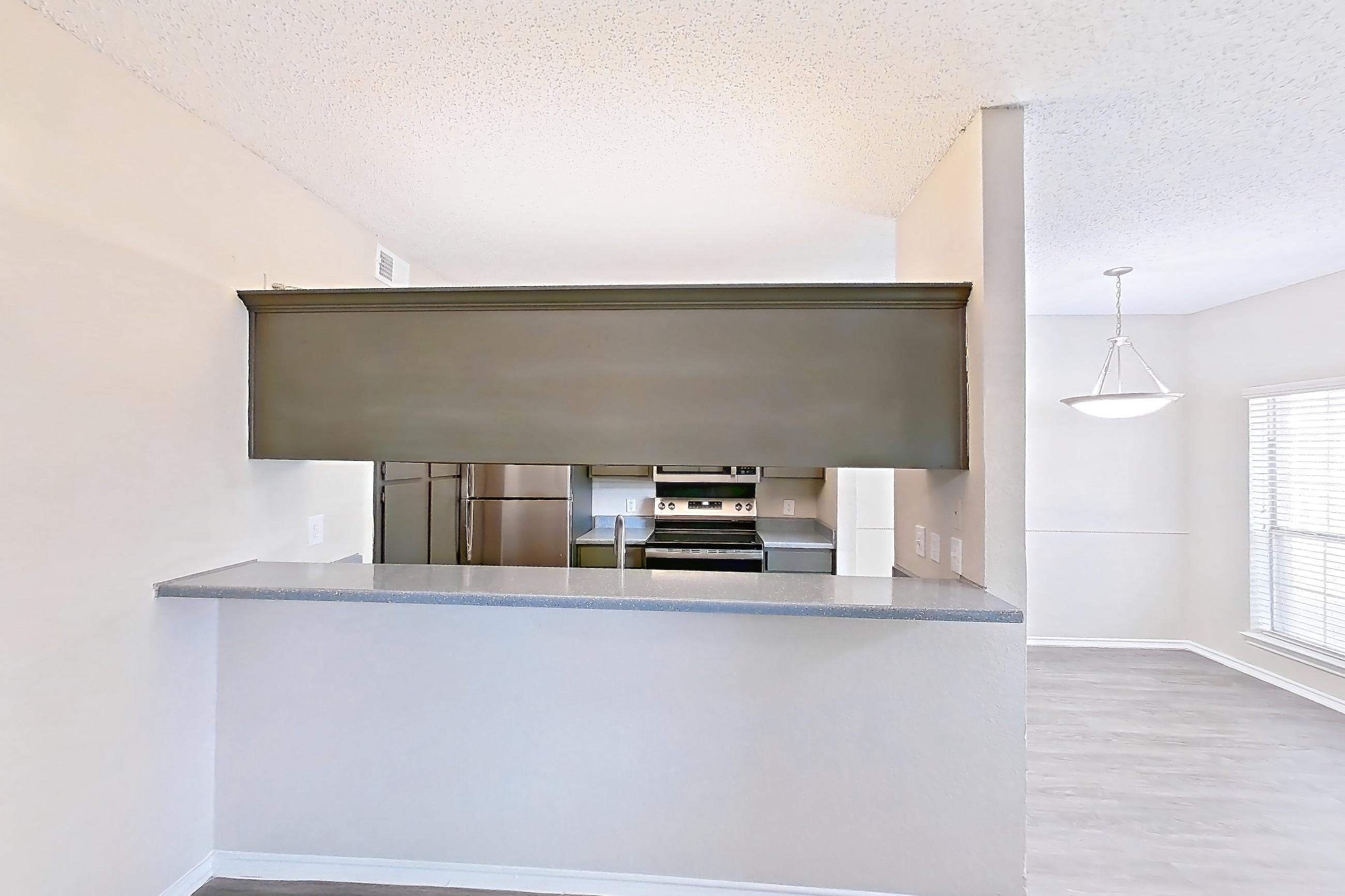 Living room with dark wood-finish flooring, electric range, light countertops, oven/range, refrigerator, and stainless steel appliances, Apartment 3013 at Waterford on the Meadow