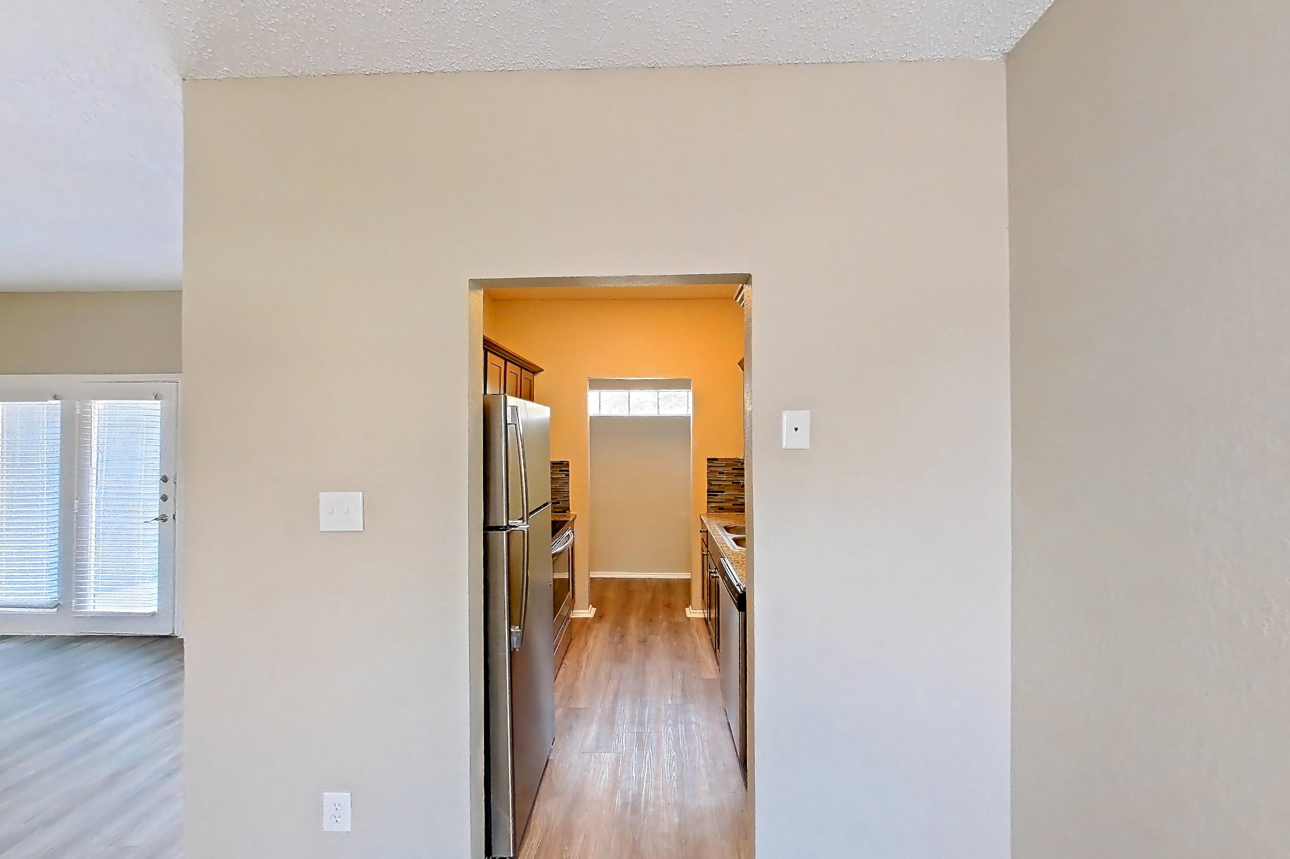 Dining room with dark wood-finish flooring, dishwasher, electric range, fireplace, light wood-finish flooring, oven/range, refrigerator, stainless steel appliances, and tile fireplace, Apartment 3924 at Waterford on the Meadow