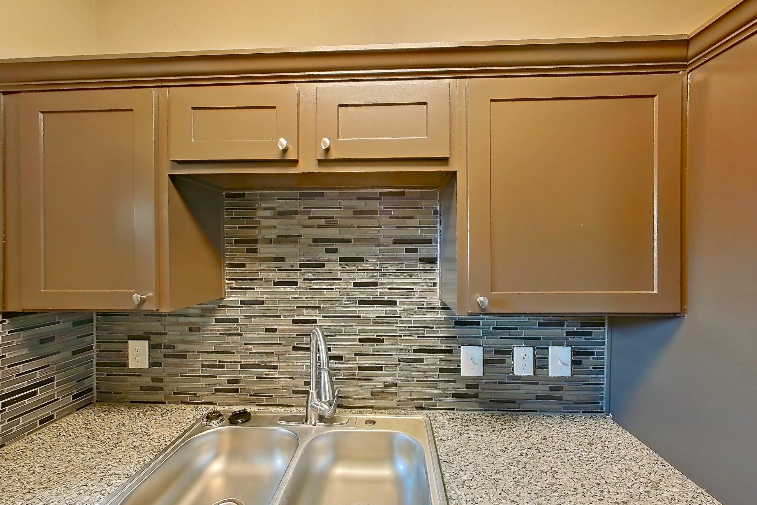 Kitchen with dishwasher, electric range, light stone countertops, light wood-finish flooring, microwave, oven/range, refrigerator, and stainless steel appliances, Apartment 3924 at Waterford on the Meadow