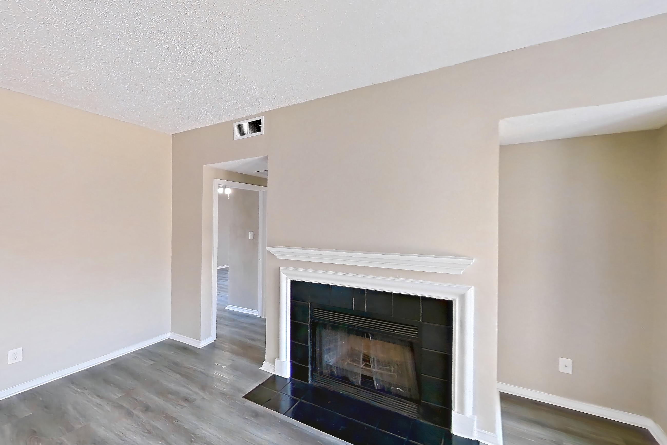 Living room with fireplace, light wood-finish flooring, and tile fireplace, Apartment 3924 at Waterford on the Meadow