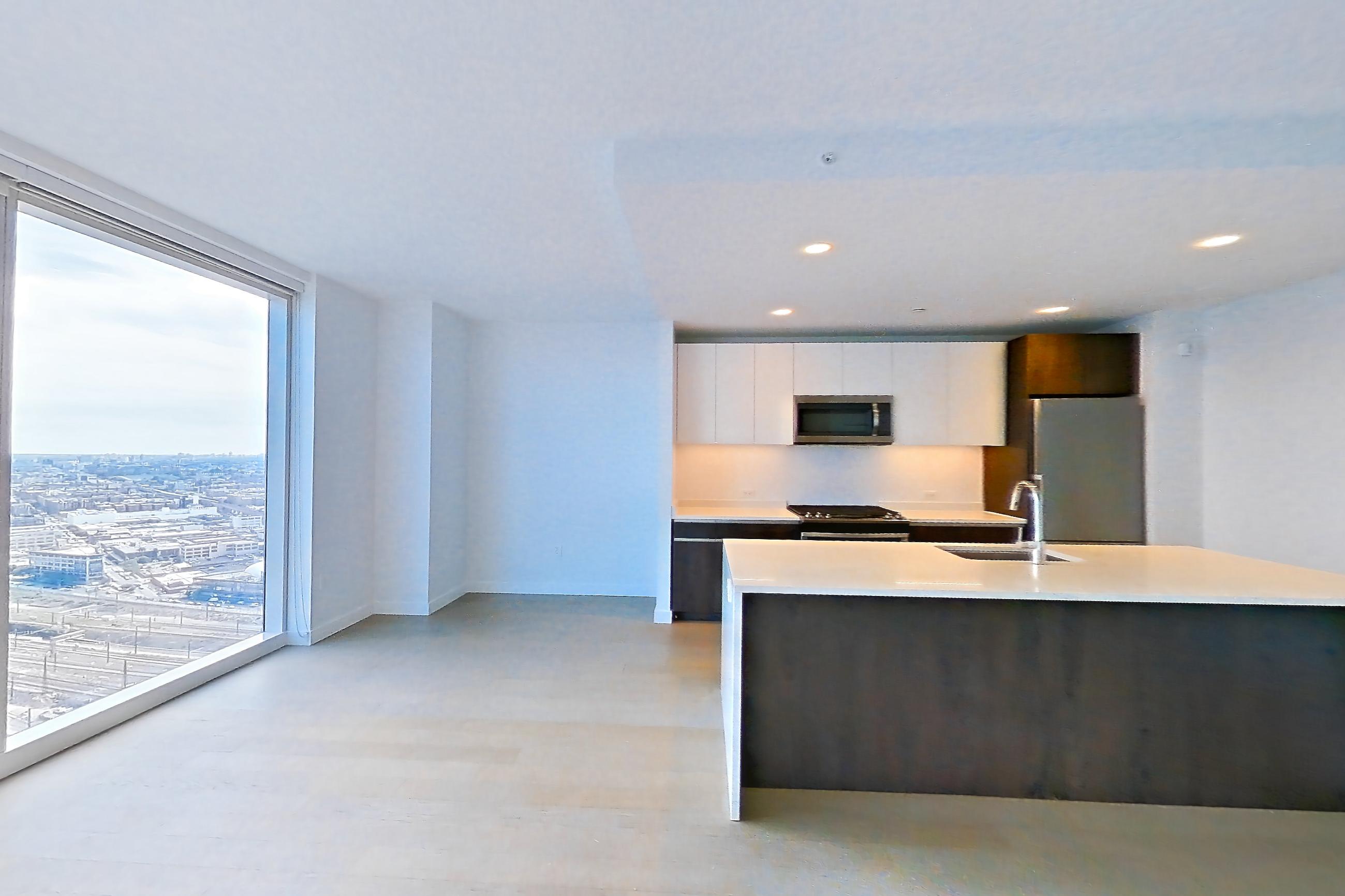 Living room with baseboard heating, electric range, kitchen island, light countertops, light wood-finish flooring, oven/range, refrigerator, and stainless steel appliances, Apartment 3JP PH1-G at Jackson Park