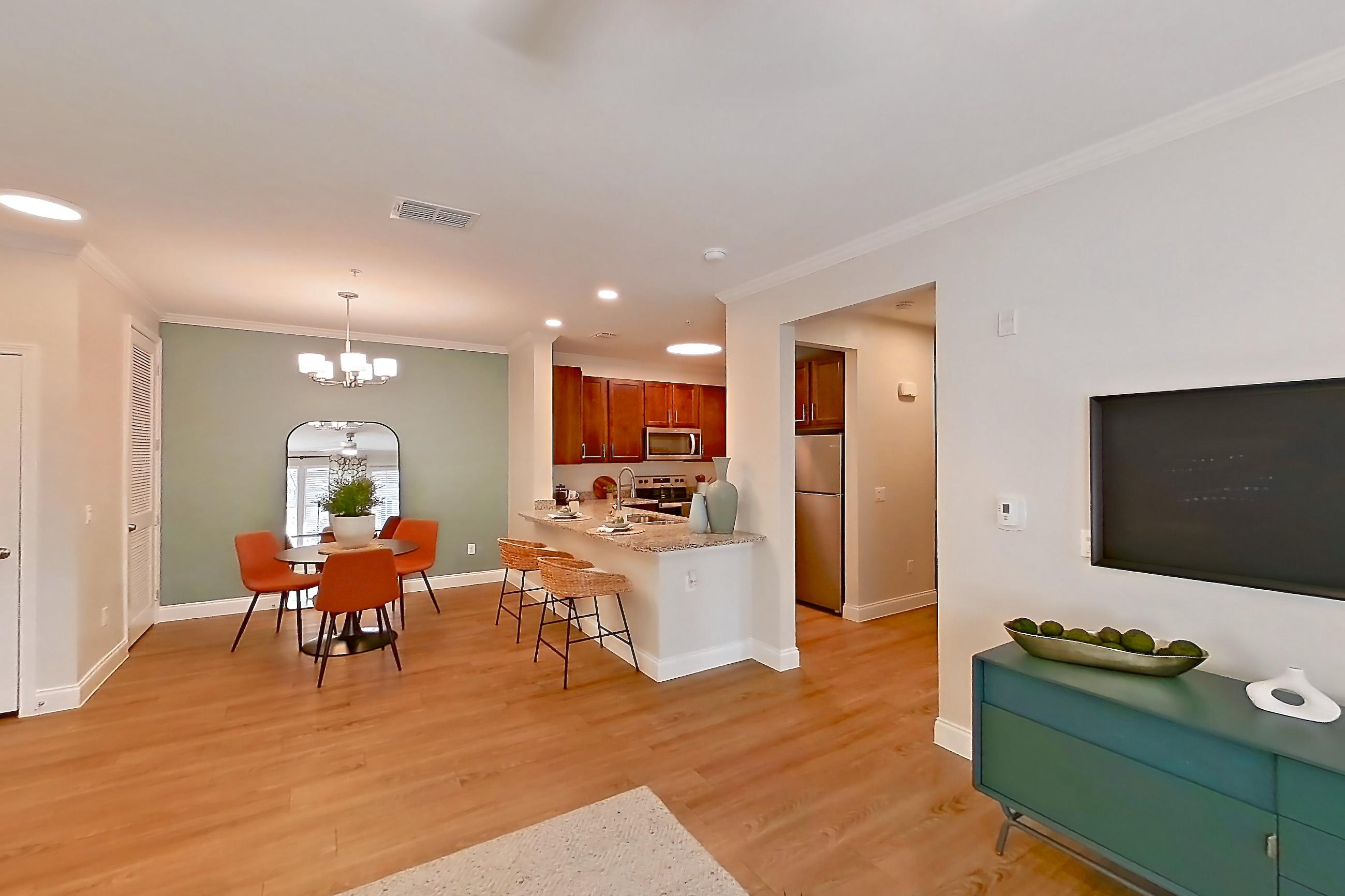 Living room with light wood-finish flooring, oven/range, refrigerator, and stainless steel appliances, Apartment 0112 at Lake Nona Water Mark