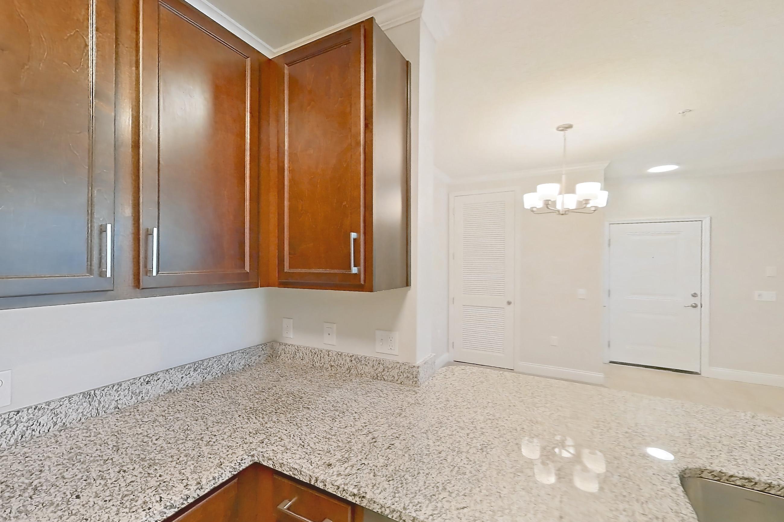 Kitchen with dishwasher, light carpet, light stone countertops, light tile flooring, refrigerator, and stainless steel appliances, Apartment 1521 at Lake Nona Water Mark